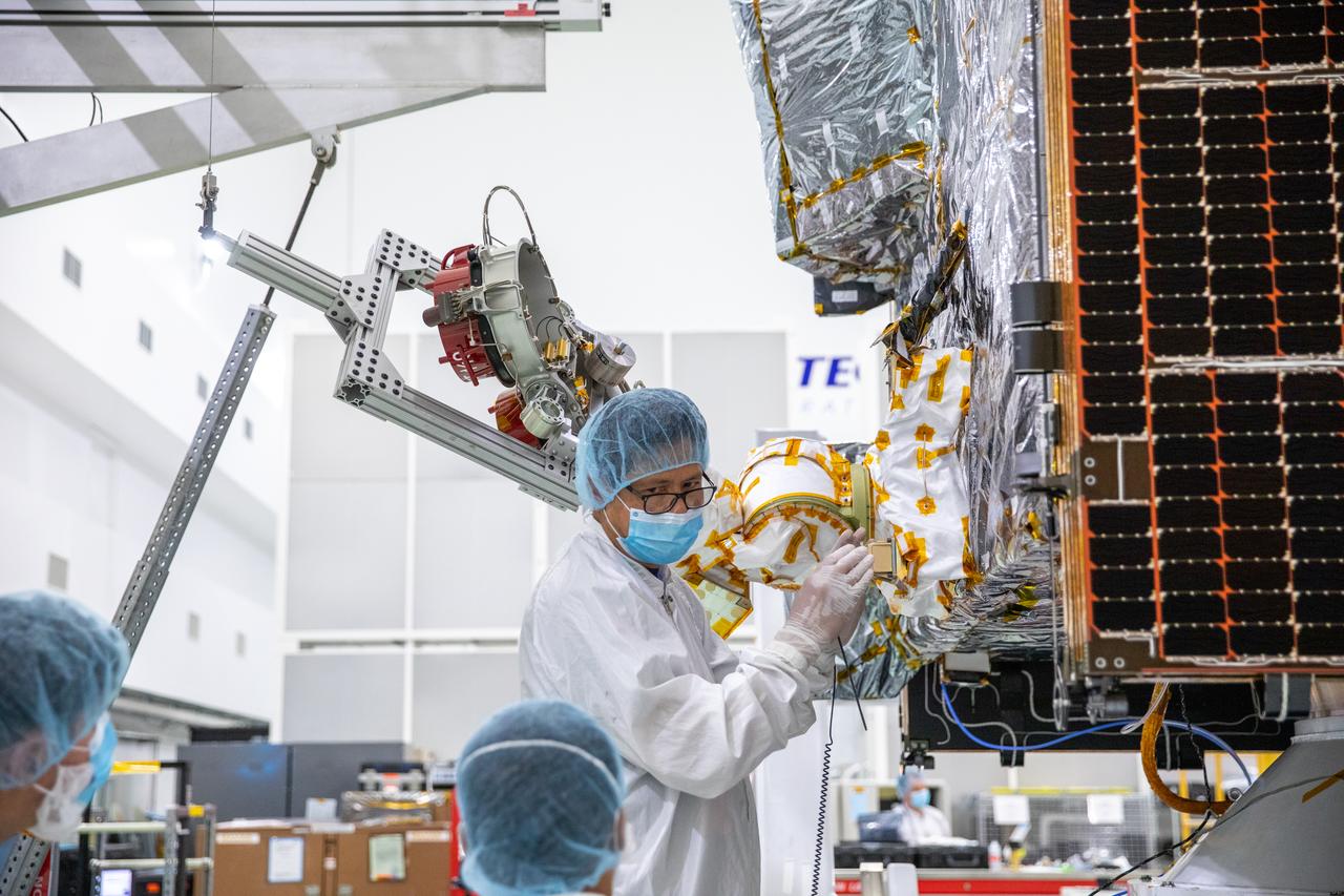 A team of engineers and technicians work on deploying and stowing stationary plasma thrusters (SPT) on NASA's Psyche spacecraft inside the Astrotech Space Operations Facility near the agency’s Kennedy Space Center in Florida on Aug. 4, 2023. This is part of the assembly, test, and launch operations preparations. The SPT are on a dual axis positioning mechanism (DAPM), and together they make a DSM, or DAPM-actuated SPT module. Psyche will launch atop a SpaceX Falcon Heavy rocket from Launch Complex 39A at Kennedy. Launch is targeted for Oct. 5, 2023. Riding with Psyche is a pioneering technology demonstration, NASA’s Deep Space Optical Communications (DSOC) experiment.