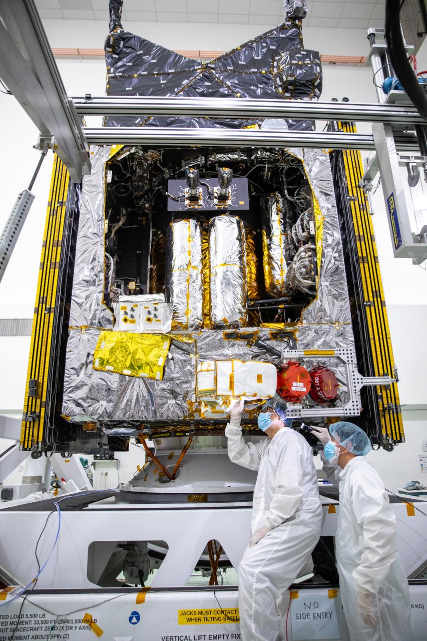 A team of engineers and technicians work on deploying and stowing stationary plasma thrusters (SPT) on NASA's Psyche spacecraft inside the Astrotech Space Operations Facility near the agency’s Kennedy Space Center in Florida on Aug. 4, 2023. This is part of the assembly, test, and launch operations preparations. The SPT are on a dual axis positioning mechanism (DAPM), and together they make a DSM, or DAPM-actuated SPT module. Psyche will launch atop a SpaceX Falcon Heavy rocket from Launch Complex 39A at Kennedy. Launch is targeted for Oct. 5, 2023. Riding with Psyche is a pioneering technology demonstration, NASA’s Deep Space Optical Communications (DSOC) experiment.