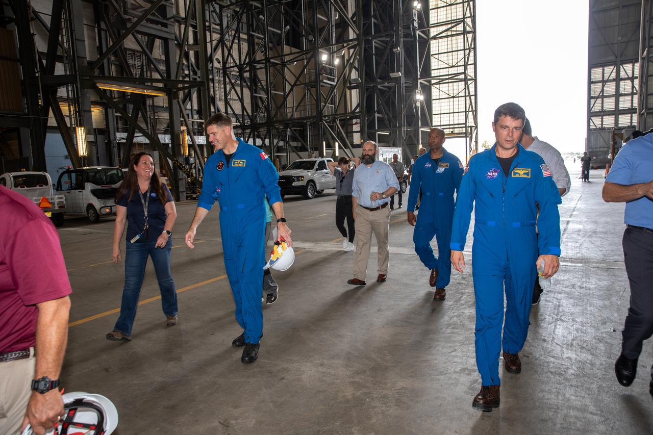 Artemis II astronauts visit NASA’s Kennedy Space Center in Florida on Aug. 7, 2023. From left, are CSA (Canadian Space Agency) astronaut Jeremy Hansen, and NASA astronaut Reid Wiseman. Behind them is NASA astronaut Victor Glover. They are with Exploration Ground Systems team members in the transfer aisle of the Vehicle Assembly Building. The approximately 10-day Artemis II flight will test NASA’s foundational human deep space exploration capabilities, the Space Launch System rocket and Orion spacecraft, for the first time with astronauts and will pave the way for lunar surface missions, including landing the first woman and the first person of color on the Moon. 