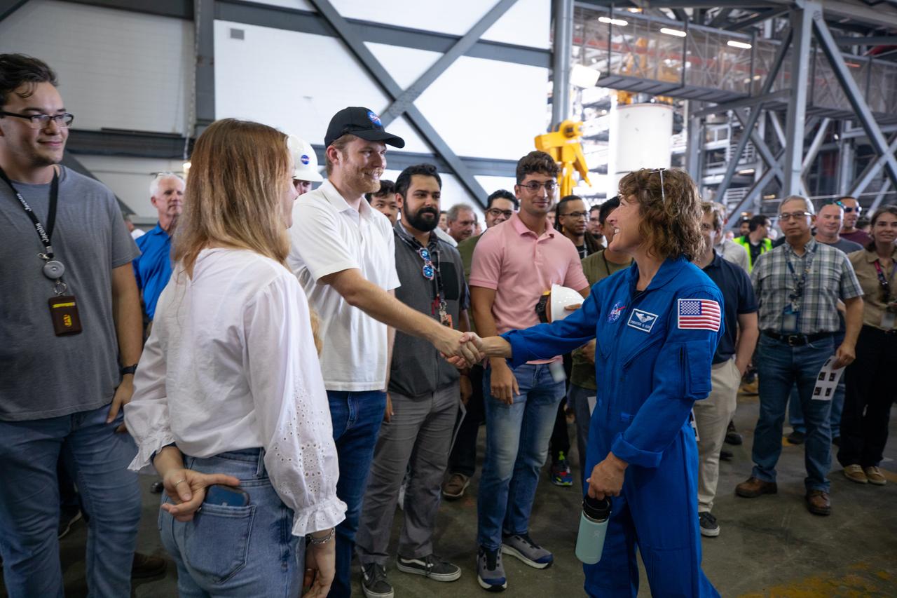 Artemis II NASA astronaut Christina Koch greets Exploration Ground Systems team members inside the transfer aisle of the Vehicle Assembly Building during a visit to the agency’s Kennedy Space Center in Florida on Aug. 7, 2023. The approximately 10-day Artemis II flight will test NASA’s foundational human deep space exploration capabilities, the Space Launch System rocket and Orion spacecraft, for the first time with astronauts and will pave the way for lunar surface missions, including landing the first woman and the first person of color on the Moon. 