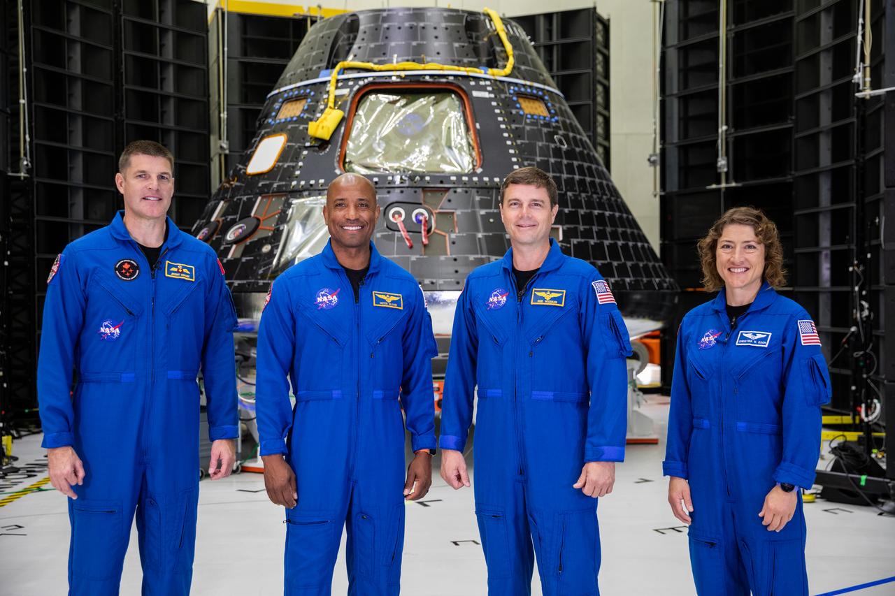 Artemis II crew members, shown inside the Neil Armstrong Operations and Checkout Building at NASA’s Kennedy Space Center in Florida, stand in front of their Orion crew module on Aug. 8, 2023. From left are: Jeremy Hansen, mission specialist; Victor Glover, pilot; Reid Wiseman, commander; and Christina Hammock Koch, mission specialist. The crew module is undergoing acoustic testing ahead of integration with the European Service Module. Artemis II is the first crewed mission on NASA’s path to establishing a long-term lunar presence for science and exploration under Artemis.