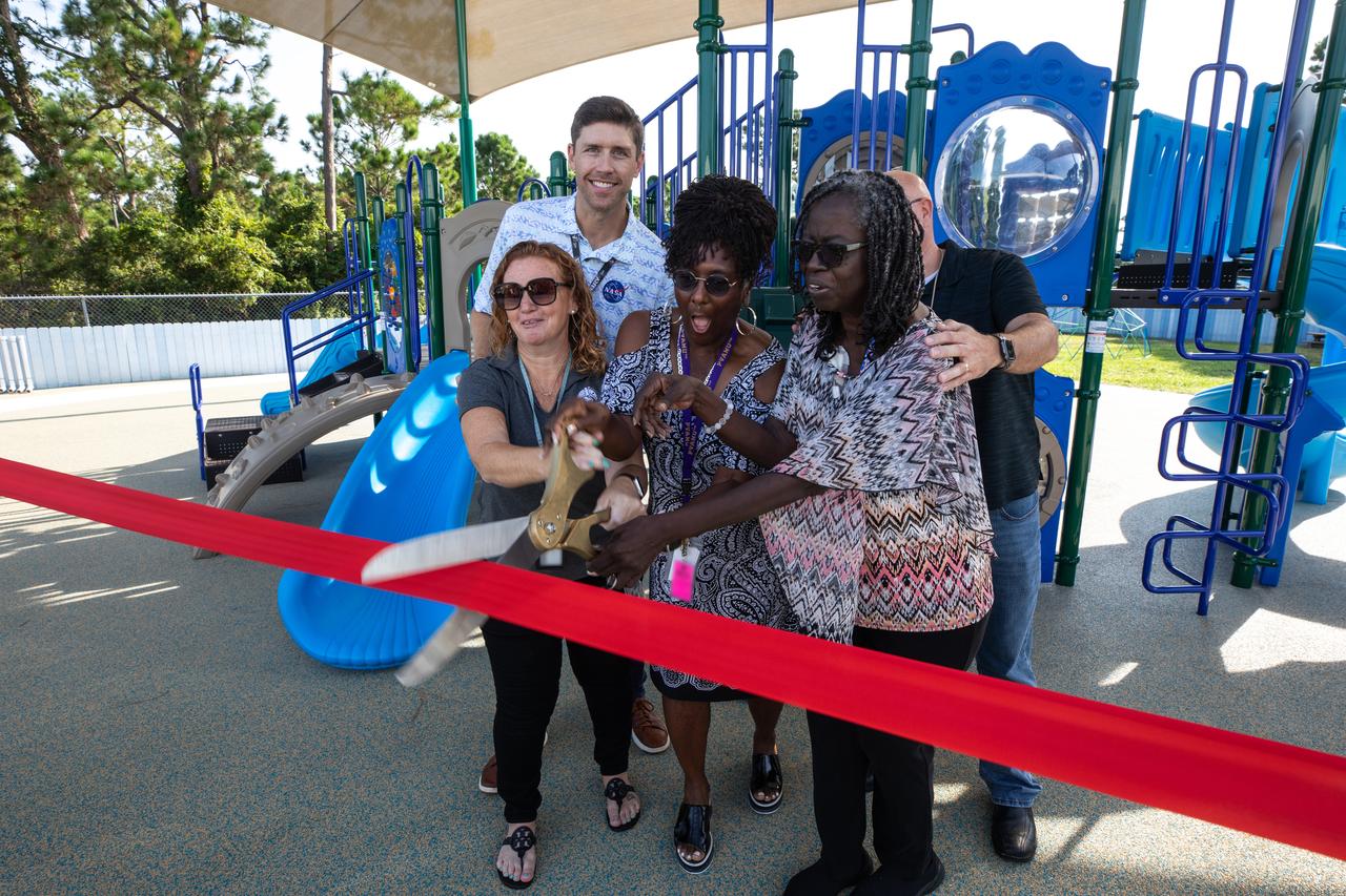 Staff members at Kennedy Space Center’s Child Development Center, along with members of the NASA Exchange, cut the ribbon to officially open a new playground at the facility on Aug. 10, 2023.