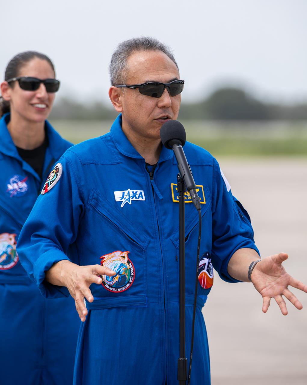 JAXA (Japan Aerospace Exploration Agency) astronaut Satoshi Furukawa addresses members of the news media during NASA’s SpaceX Crew-7 crew arrival event at the Launch and Landing Facility at Kennedy Space Center in Florida on Sunday, Aug. 20, 2023. In the background is NASA astronaut Jasmin Moghbeli. Liftoff for the Crew-7 mission is targeted for 3:49 a.m. EDT Friday, Aug. 25, 2023, from Kennedy’s Launch Complex 39A.