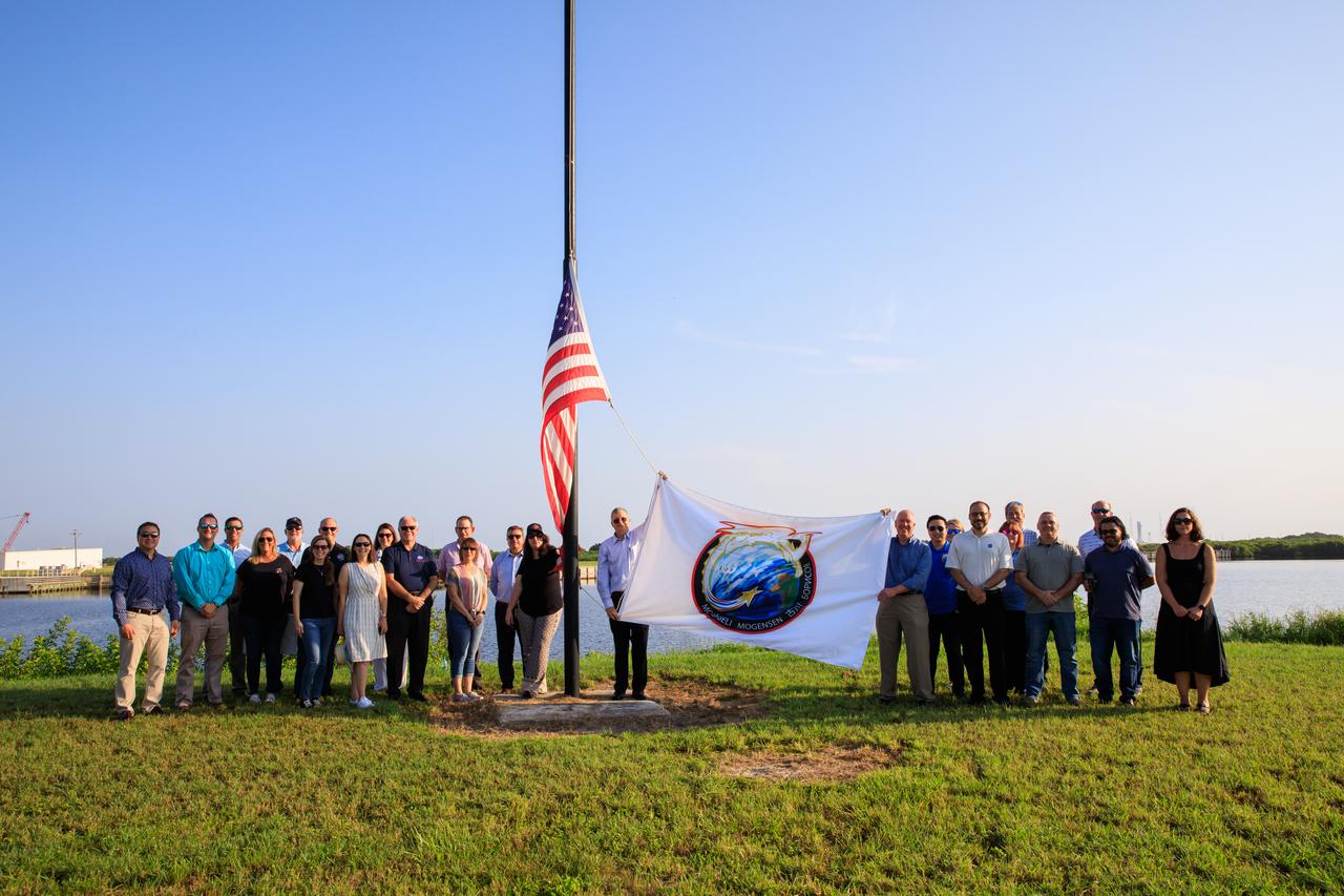 Commercial Crew Program (CCP) Manager Steve Stich, left, and CCP Contract Officer Brian Hinerth raise the Crew-7 flag on Wednesday, Aug. 23, 2023, near the countdown clock at the Press Site at NASA’s Kennedy Space Center in Florida. In the background are other CCP employees. NASA astronaut Jasmin Moghbeli, ESA (European Space Agency) astronaut Andreas Mogensen, JAXA (Japan Aerospace Exploration Agency) astronaut Satoshi Furukawa, and Roscosmos cosmonaut Konstantin Borisov will launch to the International Space Station aboard SpaceX’s Dragon spacecraft and Falcon 9 rocket. Liftoff is targeted for 3:49 a.m. EDT Friday, Aug. 25, 2023, from Kennedy’s Launch Complex 39A. Crew-7 marks the first spaceflight for Moghbeli and Borisov, and the second for Mogensen and Furukawa.