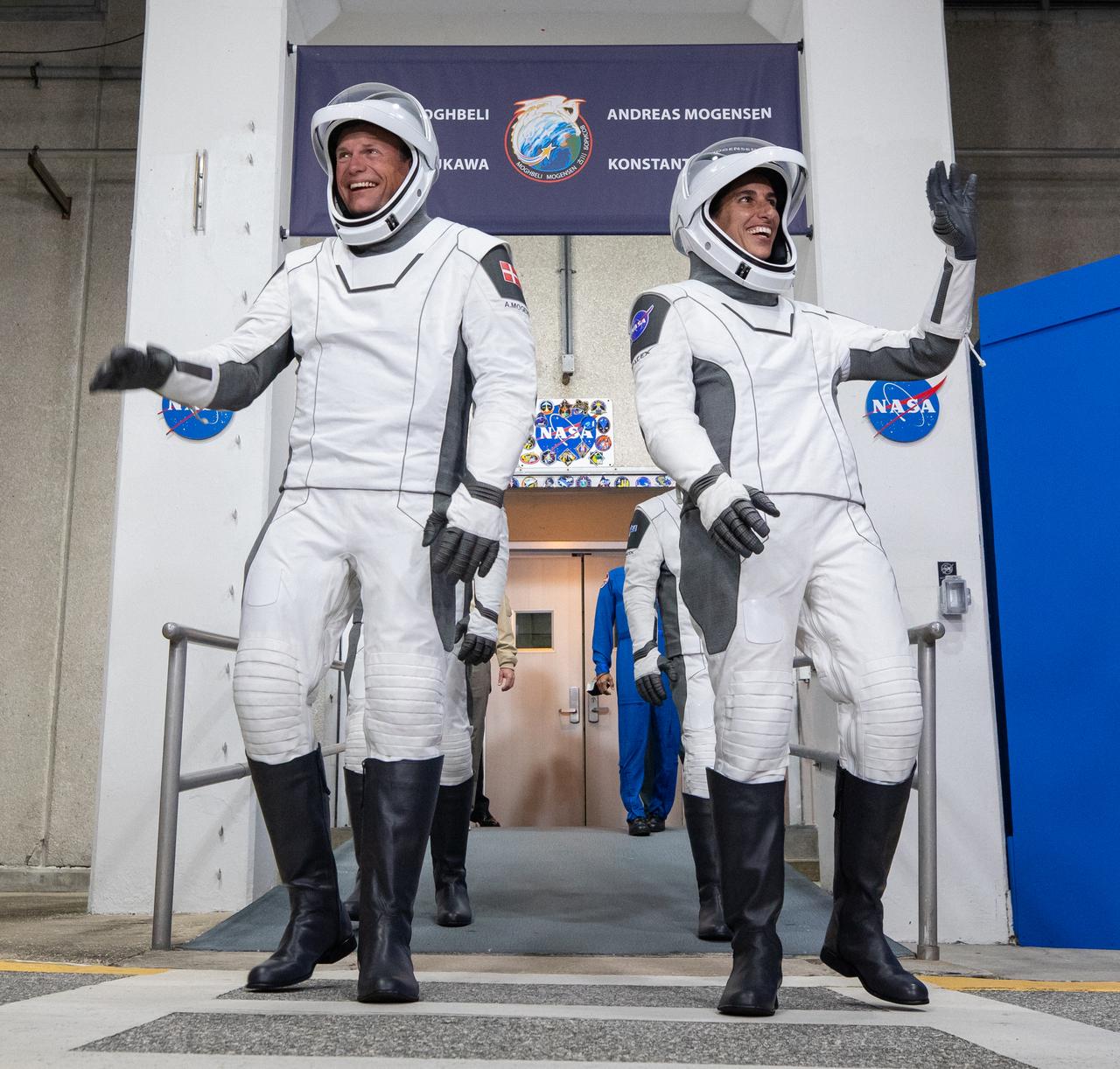 NASA’s SpaceX Crew-7 crew members, from left, ESA (European Space Agency) astronaut Andreas Mogensen and NASA astronaut Jasmin Moghbeli wave as they walk out of the Neil A. Armstrong Operations and Checkout Building at NASA’s Kennedy Space Center in Florida on Saturday, Aug. 26, 2023. They will join crewmates JAXA (Japan Aerospace Exploration Agency) astronaut Satoshi Furukawa and Roscosmos cosmonaut Konstantin Borisov on the Crew-7 mission. SpaceX’s Dragon spacecraft, powered by the company’s Falcon 9 rocket, will carry the crew to the International Space Station. Launch is scheduled to launch for 3:27 a.m. EDT.