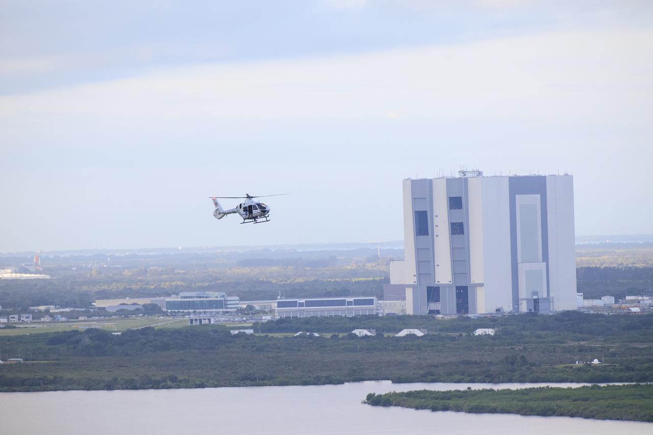 A NASA helicopter follows the convoy carrying Artemis II NASA astronauts Reid Wiseman, Victor Glover, and Christina Koch, and CSA (Canadian Space Agency) astronaut Jeremy Hansen, as they ride from Astronaut Crew Quarters in the Neil Armstrong Operations and Checkout Building to Launch Pad 39B in the Artemis crew transportation vehicles as part of an integrated ground systems test at Kennedy Space Center in Florida on Wednesday, Sept. 20, to test the crew timeline for launch day. 