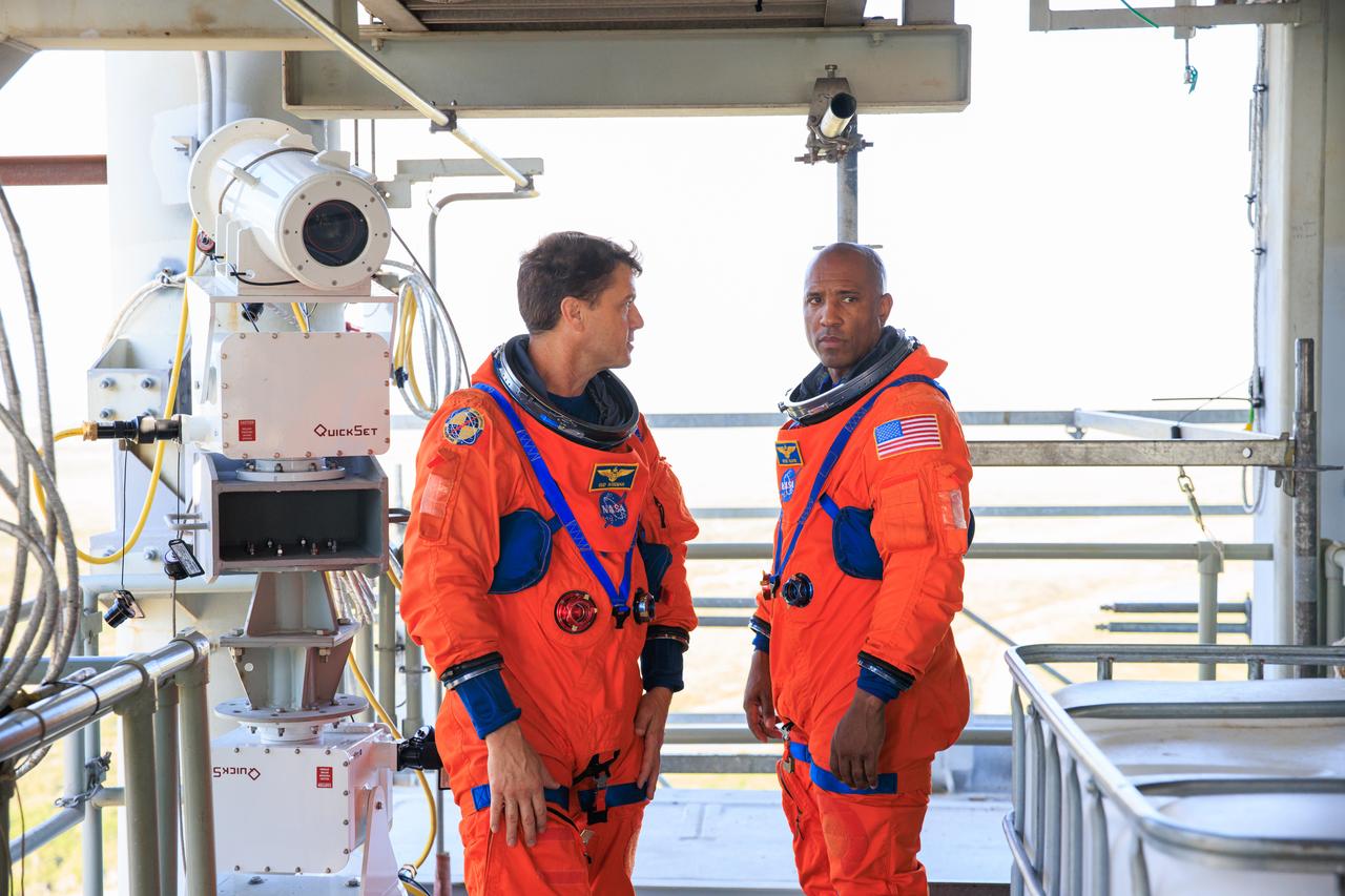 Artemis II astronauts, from left, NASA astronauts Reid Wiseman (left) and Victor Glover stand on the mobile launcher at Launch Pad 39B as part of an integrated ground systems test at Kennedy Space Center in Florida on Wednesday, Sept. 20. The test ensures the ground systems team is ready to support the crew timeline on launch day.