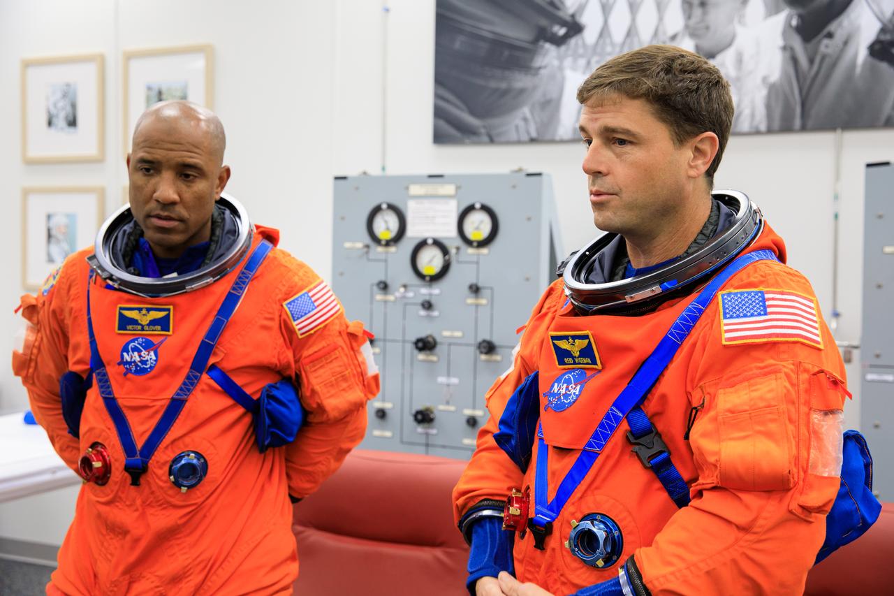Inside the Astronaut Crew Quarters at the Neil Armstrong Operations and Checkout Building at NASA’s Kennedy Space Center in Florida, Artemis II crew members NASA astronauts Victor Glover (left) and Reid Wiseman are shown wearing test versions of the Orion crew survival system spacesuits they will wear on launch day as part of an integrated ground systems test on Wednesday, Sept. 20. 