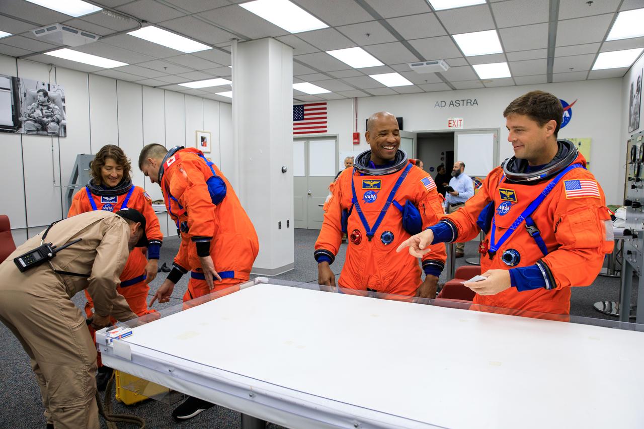 Inside the Astronaut Crew Quarters at the Neil Armstrong Operations and Checkout Building at NASA’s Kennedy Space Center in Florida, Artemis II crew members (from left) NASA astronaut Christina Koch, CSA (Canadian Space Agency) astronaut Jeremy Hansen, and NASA astronauts Reid Wiseman and Victor Glover are shown wearing test versions of the Orion crew survival system spacesuits they will wear on launch day as part of an integrated ground systems test on Wednesday, Sept. 20. 