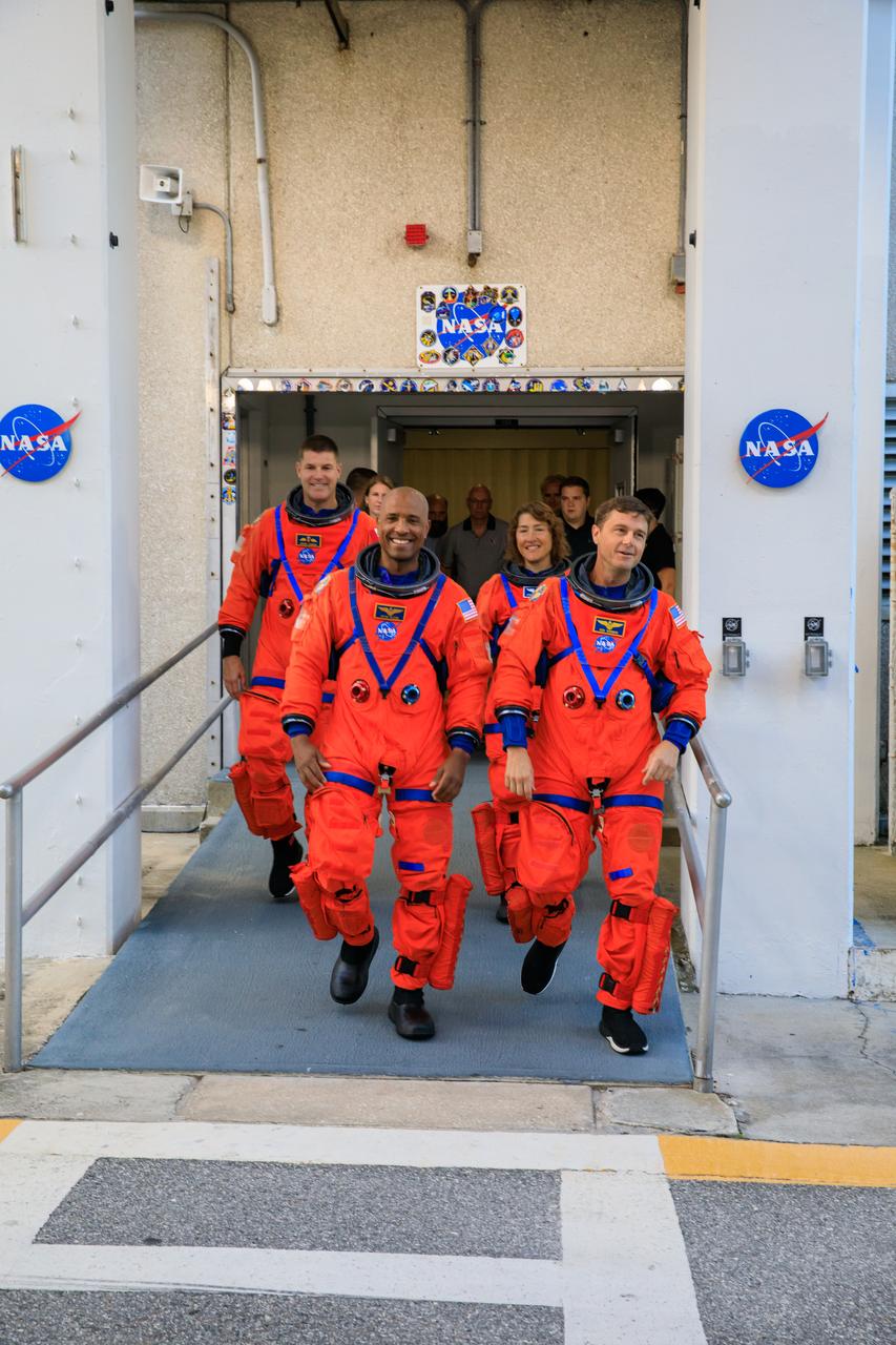 Artemis II NASA astronauts (front, from left) Victor Glover, Reid Wiseman, (back, from left) CSA (Canadian Space Agency) astronaut Jeremy Hansen, and NASA astronaut Christina Koch walk out of Astronaut Crew Quarters inside the Neil Armstrong Operations and Checkout Building to the Artemis crew transportation vehicles prior to traveling to Launch Pad 39B as part of an integrated ground systems test at Kennedy Space Center in Florida on Wednesday, Sept. 20, to test the crew timeline for launch day.
