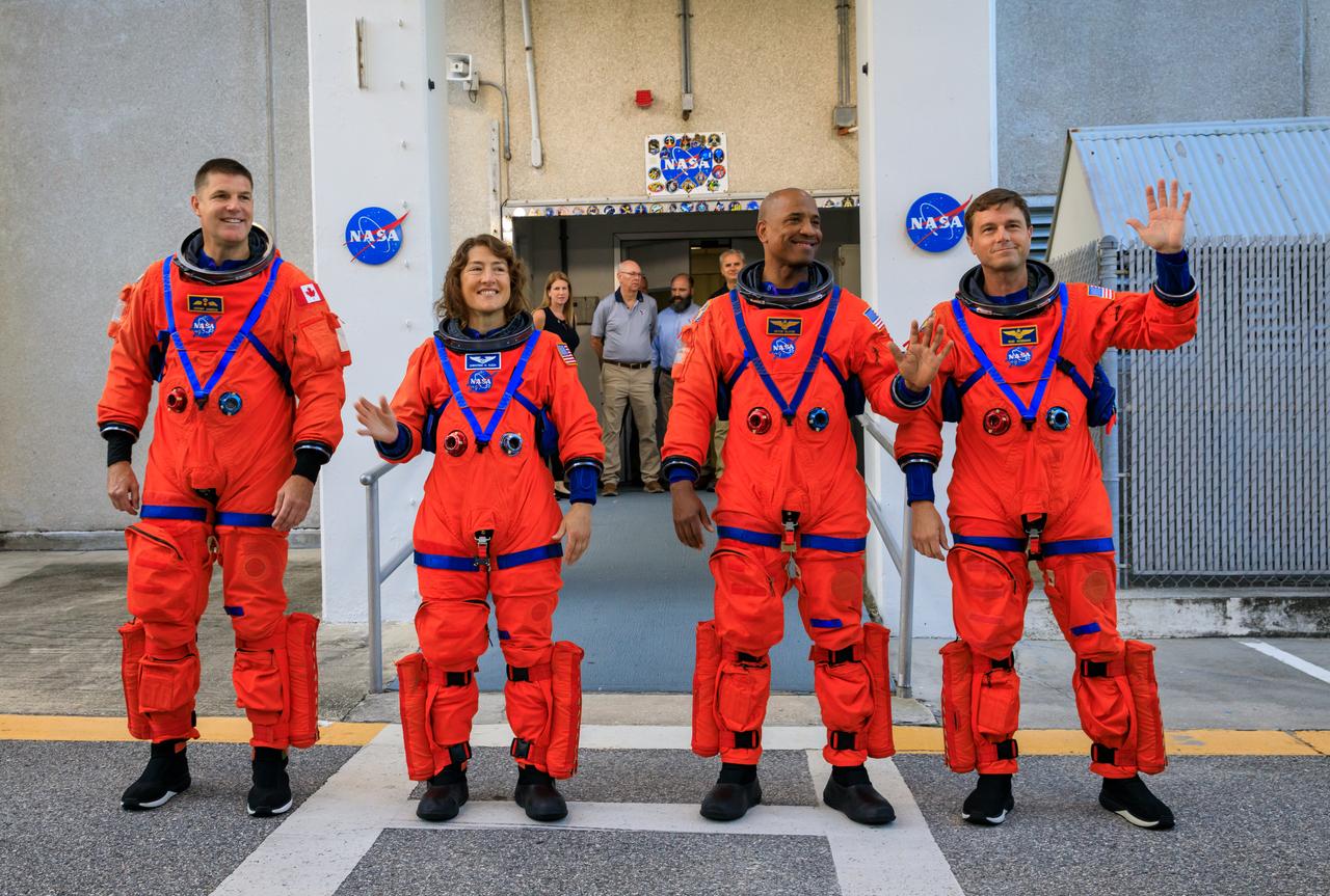 Artemis II crew members (from left) CSA (Canadian Space Agency) astronaut Jeremy Hansen, and NASA astronauts Christina Koch, Victor Glover, and Reid Wiseman walk out of Astronaut Crew Quarters inside the Neil Armstrong Operations and Checkout Building to the Artemis crew transportation vehicles prior to traveling to Launch Pad 39B as part of an integrated ground systems test at Kennedy Space Center in Florida on Wednesday, Sept. 20, to test the crew timeline for launch day.
