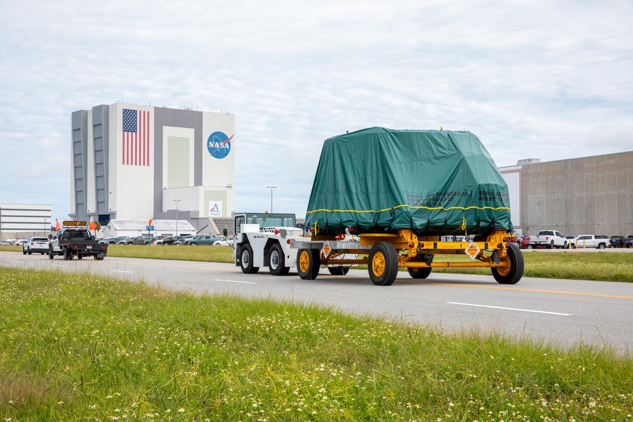 One of two Artemis II aft skirts for NASA's Space Launch System (SLS) rocket’s twin solid rocket boosters is transported from the Booster Fabrication Facility to the Rotation Processing and Surge Facility (RPSF) at the agency’s Kennedy Space Center in Florida on Monday, Sept. 25, 2023. The aft skirts were refurbished by Northrop Grumman and house the thrust vector control system, which controls 70 percent of the steering during initial ascent of the SLS rocket. The segments will remain in the RPSF until ready for stacking with the forward and aft parts of the boosters on the mobile launcher in High Bay 3 of the Vehicle Assembly Building. Artemis II astronauts Reid Wiseman, Victor Glover, Christina Koch, and Jeremy Hansen will launch from Kennedy, traveling around the Moon on the first crewed mission under Artemis that will test all of the Orion spacecraft’s systems.
