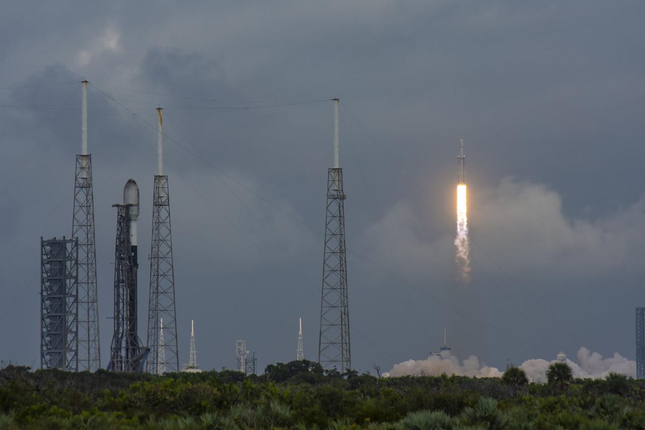 NASA’s Psyche spacecraft, atop a SpaceX Falcon Heavy rocket, lifts off from Kennedy Space Center’s historic Launch Complex 39A in Florida at 10:19 a.m. EDT on Friday, Oct. 13, 2023. At left is a SpaceX Falcon 9 rocket standing tall on the pad at Cape Canaveral Space Force Station’s Space Launch Complex 40. The Psyche mission will study a metal-rich asteroid with the same name, located in the main asteroid belt between Mars and Jupiter. This is NASA’s first mission to study an asteroid that has more metal than rock or ice. Riding with Psyche is a pioneering technology demonstration – NASA’s Deep Space Optical Communications (DSOC) experiment – which will be the first test of laser communications beyond the Moon. 