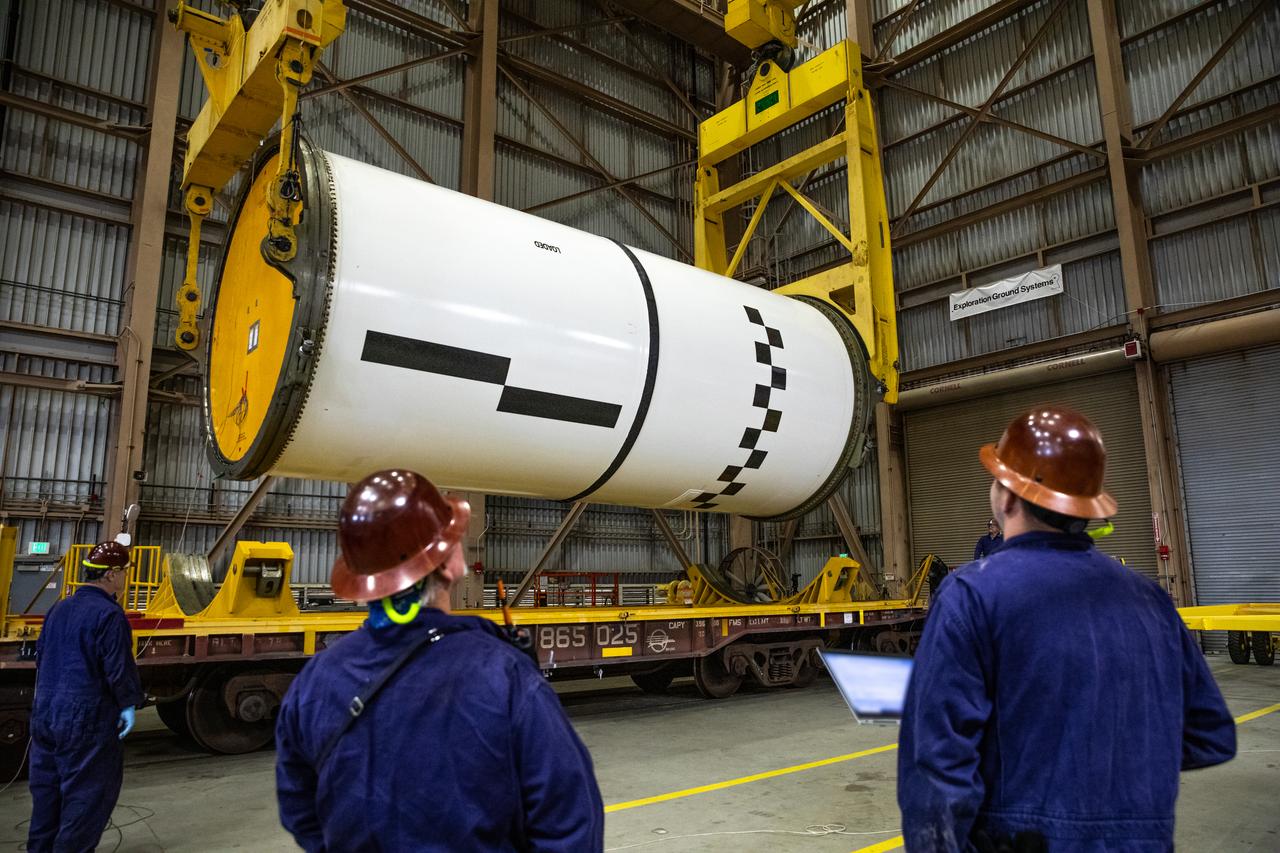 Engineers and technicians process the right forward center segment of the Space Launch System solid rocket boosters for the Artemis II mission inside the Rotation, Processing and Surge Facility (RPSF) at NASA’s Kennedy Space Center in Florida on Tuesday, Nov. 27, 2023.   The team has been examining the 10 booster segments one-by-one then lifting them to make sure they are ready for integration and launch before moving them to the Vehicle Assembly Building for stacking atop the mobile launcher. Artemis II astronauts Reid Wiseman, Victor Glover, Christina Koch, and Jeremy Hansen will blast off from Kennedy and travel around the moon for the agency’s first crewed mission under Artemis that will test all of the Orion spacecraft’s systems.