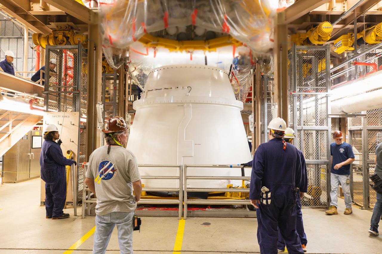 Technicians with Exploration Ground Systems perform pre-mate inspections of the Northrop Grumman-manufactured right aft exit cone of the Artemis II Space Launch Systems solid rocket boosters on Wednesday, Dec. 13, 2023, inside the Rotation, Processing and Surge Facility (RPSF) at NASA’s Kennedy Space Center in Florida. Each of the two aft exit cones will be prepared for the agency’s Artemis II flight and attach to the aft segments of the Space Launch Systems solid rocket boosters. The exit cones act like a battery pack to provide added thrust for the boosters while protecting the aft skirts from thermal environment during launch.
