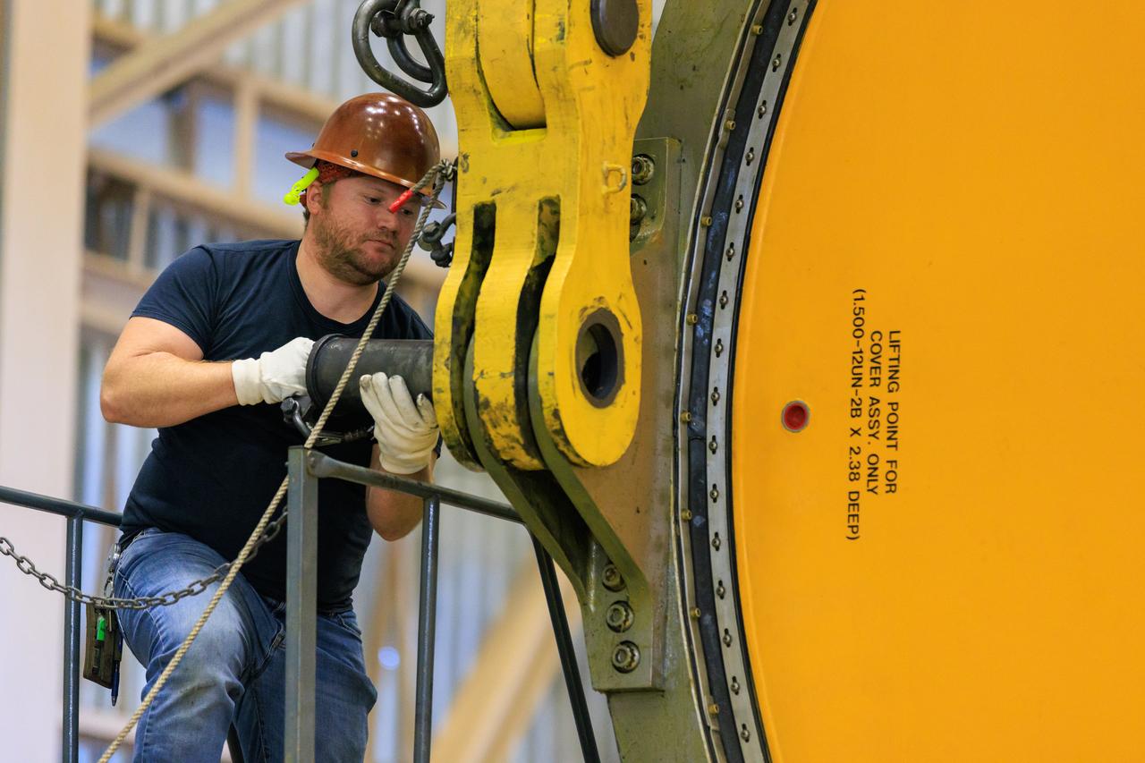 Following the successful propellant grain inspection of two segments of the solid rocket boosters for NASA’s Space Launch System inside the Rotation, Processing and Surge Facility at NASA’s Kennedy Space Center in Florida, crews on Thursday, Dec. 21, 2023, rotate and lift the segments from horizontal into a vertical position in preparation for the agency’s Artemis II launch campaign.  The Artemis II mission will send four astronauts around the Moon as part of the agency’s effort to establish a long-term science and exploration presence at the Moon, and eventually Mars. 