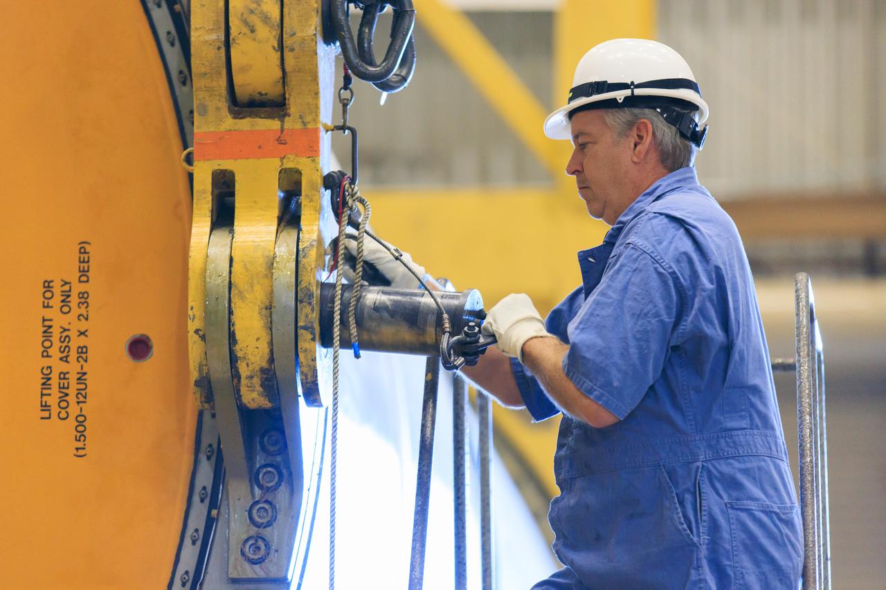 Following the successful propellant grain inspection of two segments of the solid rocket boosters for NASA’s Space Launch System inside the Rotation, Processing and Surge Facility at NASA’s Kennedy Space Center in Florida, crews on Thursday, Dec. 21, 2023, rotate and lift the segments from horizontal into a vertical position in preparation for the agency’s Artemis II launch campaign.  The Artemis II mission will send four astronauts around the Moon as part of the agency’s effort to establish a long-term science and exploration presence at the Moon, and eventually Mars. 