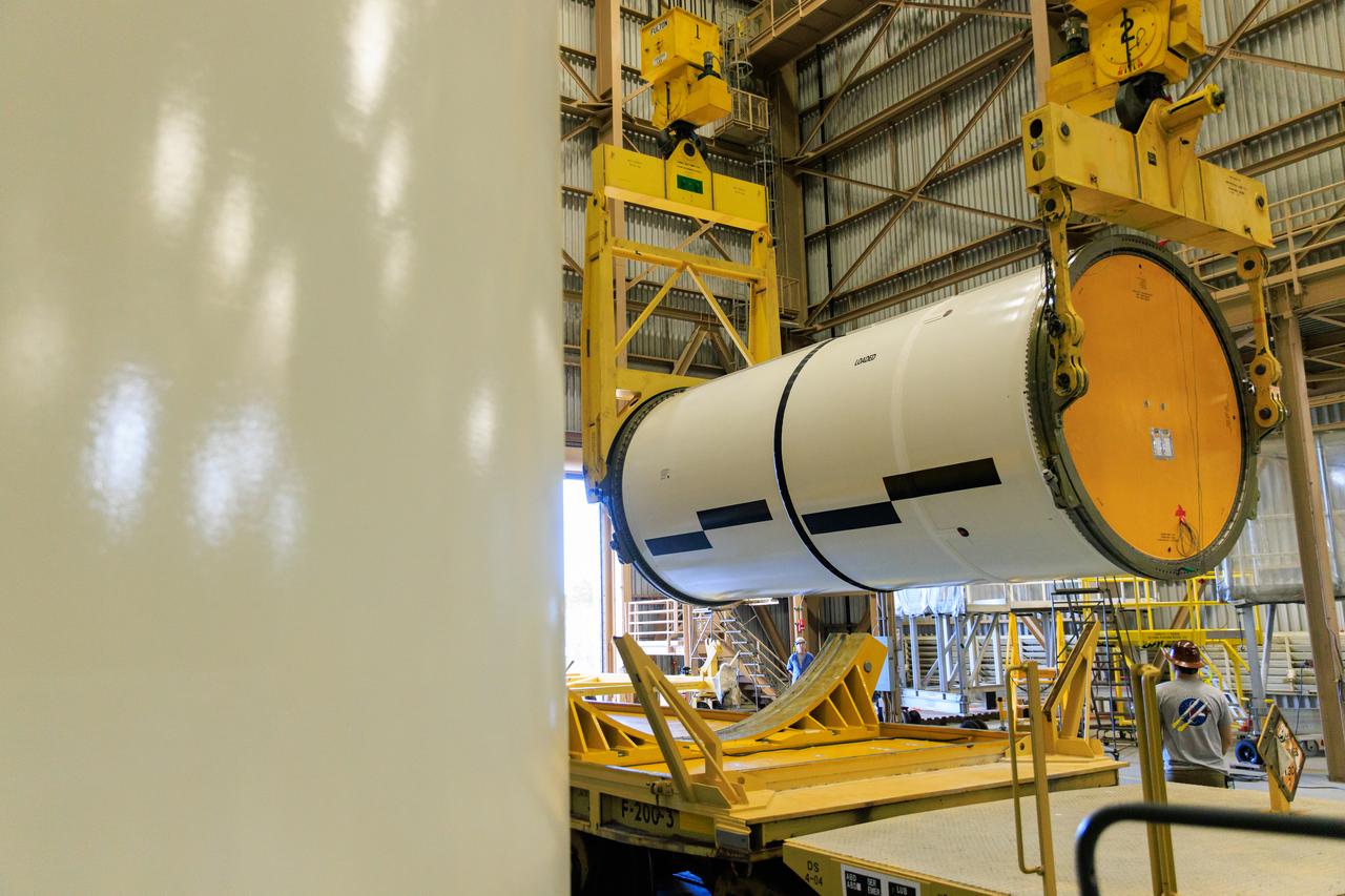 Following the successful propellant grain inspection of two segments of the solid rocket boosters for NASA’s Space Launch System inside the Rotation, Processing and Surge Facility at NASA’s Kennedy Space Center in Florida, crews on Thursday, Dec. 21, 2023, rotate and lift the segments from horizontal into a vertical position in preparation for the agency’s Artemis II launch campaign.  The Artemis II mission will send four astronauts around the Moon as part of the agency’s effort to establish a long-term science and exploration presence at the Moon, and eventually Mars. 
