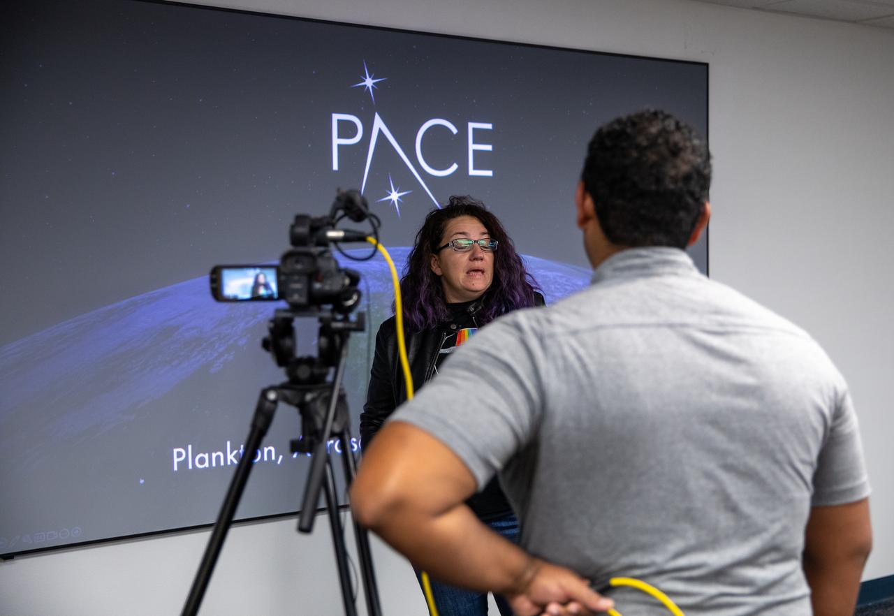 Ivona Cetinić, PACE Project Science Lead for Aquatic Biogeochemistry, is photographed speaking with a member of the media about NASA’s PACE (Plankton, Aerosol, Cloud, ocean Ecosystem) spacecraft on Wednesday, Jan. 3, 2024, during a NASA-hosted media day at the Astrotech Space Operations Facility near NASA’s Kennedy Space Center in Florida. NASA invited journalists for the opportunity to speak with mission subject matter experts and view the spacecraft before it is encapsulated into its payload fairing for its launch aboard a SpaceX Falcon 9 rocket no earlier than Tuesday, Feb. 6, 2024, from Space Launch Complex 40 at Cape Canaveral Space Force Station in Florida.