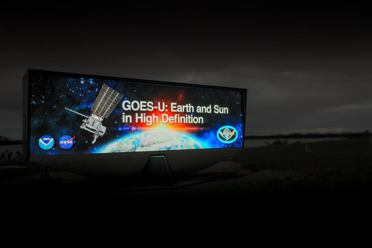 NOAA’s Geostationary Operational Environmental Satellite-U (GOES-U) mission graphic is displayed on the historic countdown clock at Kennedy Space Center’s NASA News Center in Florida on Tuesday, Jan. 23, 2024. GOES-U is the fourth and final satellite in NOAA's GOES-R series of advanced geostationary weather satellites. Data from the GOES satellite constellation – consisting of the GOES-R, GOES-S, GOES-T and GOES-U spacecraft – enables forecasters to predict, observe, and track local weather events that affect public safety like thunderstorms, hurricanes, and wildfires.