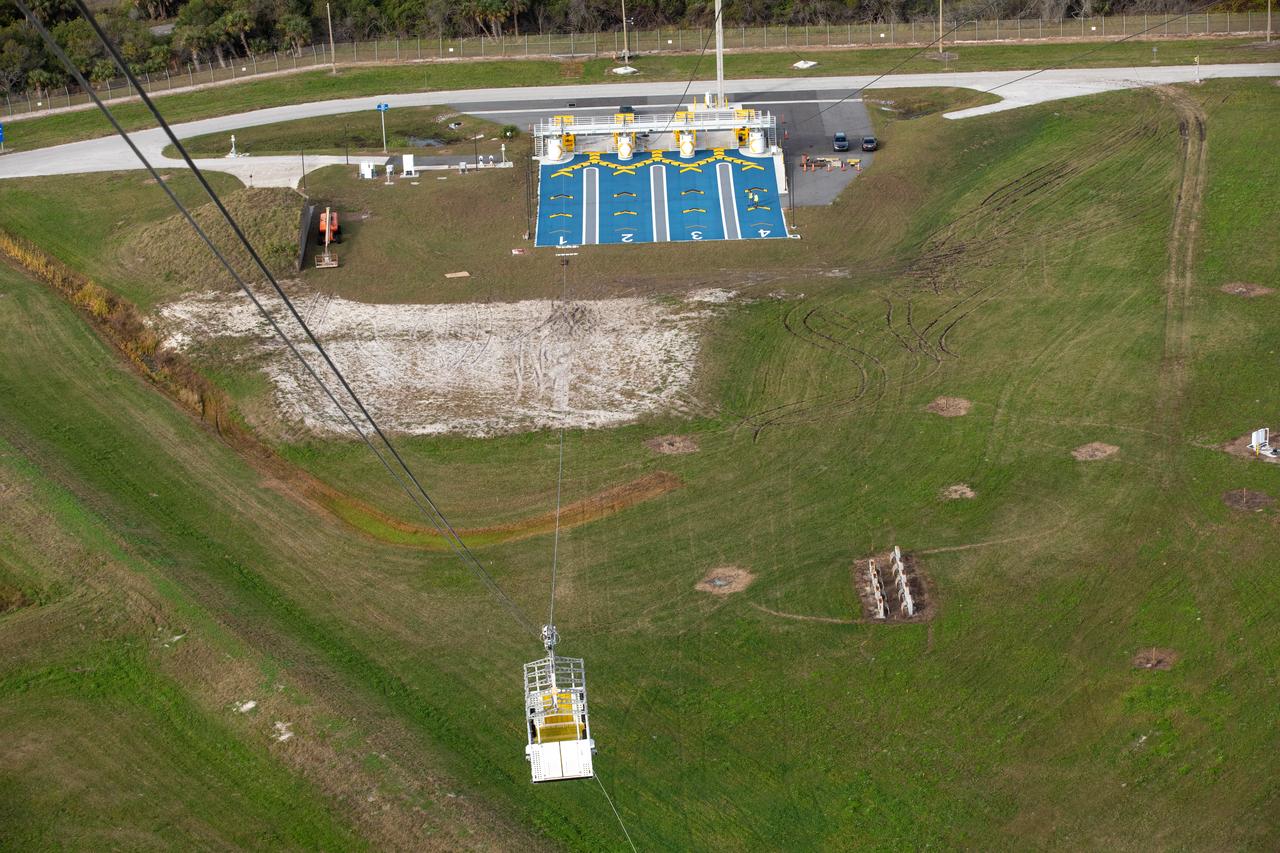 Teams with NASA’s Exploration Ground Systems Program, in preparation for the agency’s Artemis II crewed mission to the Moon, begin installing the first of four emergency egress baskets on the mobile launcher at Launch Complex 39B at the agency’s Kennedy Space Center in Florida on Wednesday, Jan. 24, 2024. The baskets, similar to gondolas on ski lifts, are used in the case of a pad abort emergency to enable astronauts and other pad personnel a way to quickly escape away from the mobile launcher to the base of the pad and where waiting emergency transport vehicles will then drive them away.
