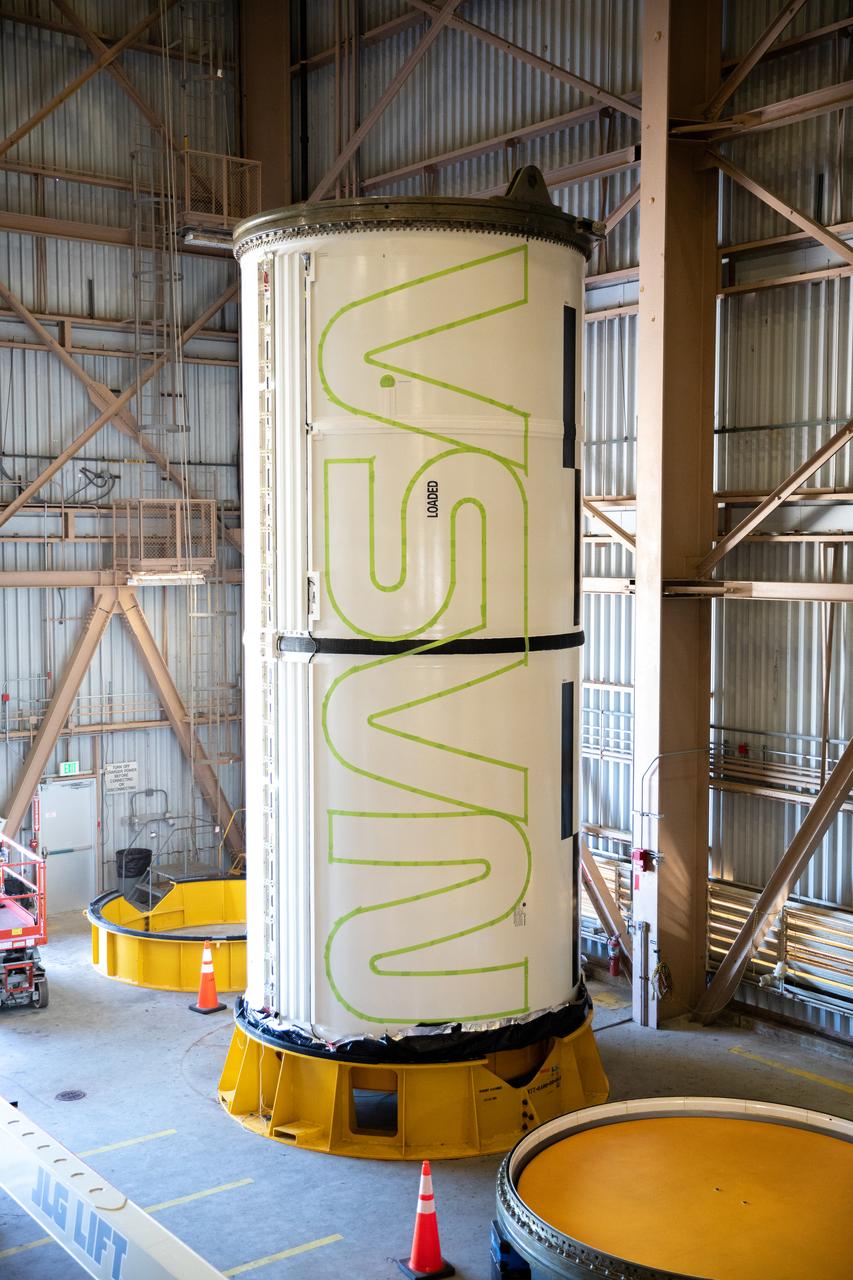 Workers with NASA’s Exploration Ground Systems (EGS) paint the bright red NASA “worm” logo on the side of an Artemis II solid rocket booster segment inside the Rotation, Processing and Surge Facility (RPSF) at Kennedy Space Center in Florida on Tuesday, Jan. 30, 2024. The EGS team used a laser projector to mask off the logo with tape, then painted the first coat of the iconic design. The booster segments will help propel the Space Launch System (SLS) rocket on the Artemis II mission to send four astronauts around the Moon as part of the agency’s effort to establish a long-term science and exploration presence at the Moon, and eventually Mars.