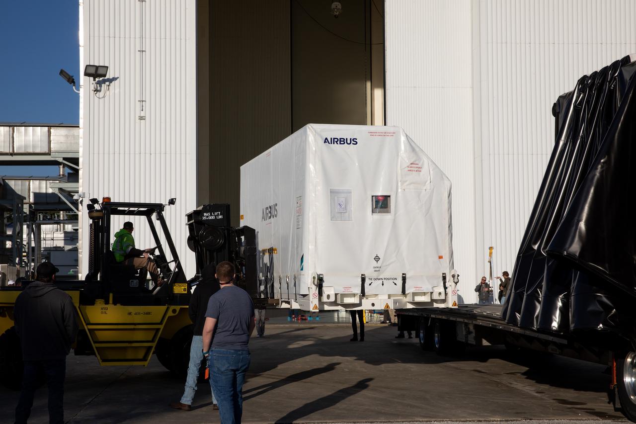 The transport carrier containing the five-panel solar arrays for NASA’s Europa Clipper spacecraft arrives at the Payload Hazardous Servicing Facility at the agency’s Kennedy Space Center in Florida on Wednesday, Feb. 21, 2024. The arrival completes the solar array journey which began in Leiden, Netherlands, where Airbus workers assembled them before shipping them by barge to Port of Miami in Florida and transporting them by truck to Kennedy. The solar arrays will attach to the spacecraft to power it on the 1.8-billion-mile journey to study Jupiter’s icy moon, Europa. Launch on a SpaceX Falcon Heavy rocket is no earlier than October 2024.
