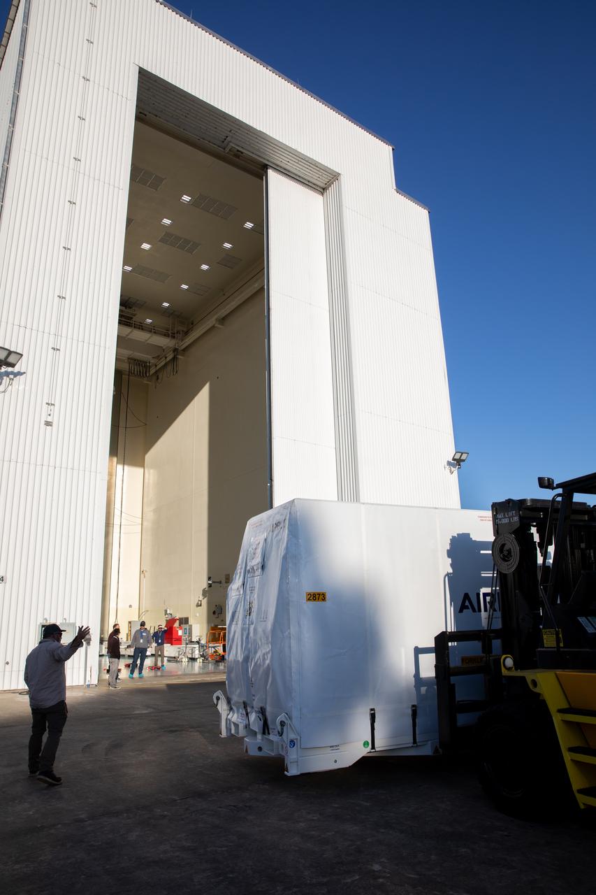 The transport carrier containing the five-panel solar arrays for NASA’s Europa Clipper spacecraft arrives at the Payload Hazardous Servicing Facility at the agency’s Kennedy Space Center in Florida on Wednesday, Feb. 21, 2024. The arrival completes the solar array journey which began in Leiden, Netherlands, where Airbus workers assembled them before shipping them by barge to Port of Miami in Florida and transporting them by truck to Kennedy. The solar arrays will attach to the spacecraft to power it on the 1.8-billion-mile journey to study Jupiter’s icy moon, Europa. Launch on a SpaceX Falcon Heavy rocket is no earlier than October 2024.