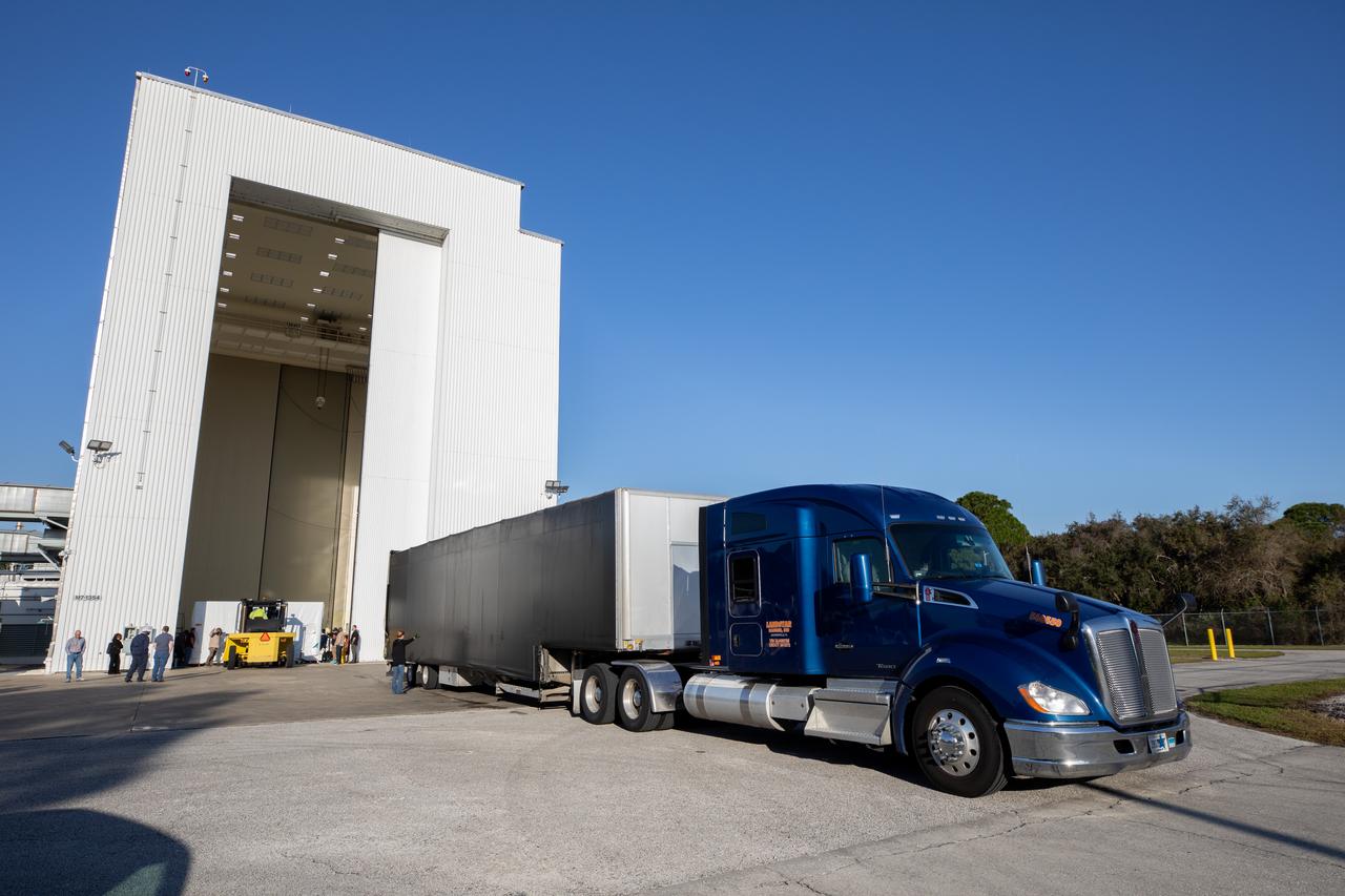 The transport carrier containing the five-panel solar arrays for NASA’s Europa Clipper spacecraft arrives at the Payload Hazardous Servicing Facility at the agency’s Kennedy Space Center in Florida on Wednesday, Feb. 21, 2024. The arrival completes the solar array journey which began in Leiden, Netherlands, where Airbus workers assembled them before shipping them by barge to Port of Miami in Florida and transporting them by truck to Kennedy. The solar arrays will attach to the spacecraft to power it on the 1.8-billion-mile journey to study Jupiter’s icy moon, Europa. Launch on a SpaceX Falcon Heavy rocket is no earlier than October 2024.