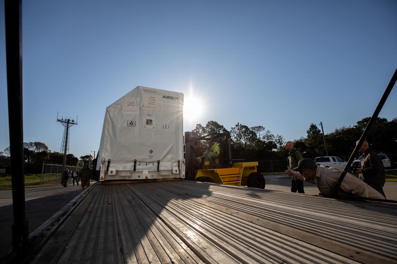 The transport carrier containing the five-panel solar arrays for NASA’s Europa Clipper spacecraft arrives at the Payload Hazardous Servicing Facility at the agency’s Kennedy Space Center in Florida on Wednesday, Feb. 21, 2024. The arrival completes the solar array journey which began in Leiden, Netherlands, where Airbus workers assembled them before shipping them by barge to Port of Miami in Florida and transporting them by truck to Kennedy. The solar arrays will attach to the spacecraft to power it on the 1.8-billion-mile journey to study Jupiter’s icy moon, Europa. Launch on a SpaceX Falcon Heavy rocket is no earlier than October 2024.