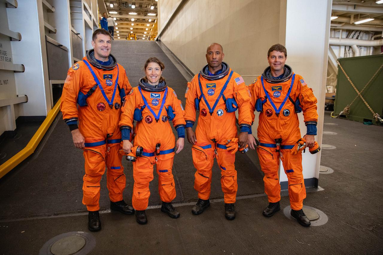 NASA’s Artemis II crew members (left to right) CSA (Canadian Space Agency) astronaut Jeremy Hansen, and NASA astronauts Christina Koch, Victor Glover, and Reid Wiseman pose for a photograph in the well deck of the USS San Diego during Underway Recovery Test 11 (URT-11), as NASA’s Exploration Ground System’s Landing and Recovery team and partners from the Department of Defense aboard the ship practice recovery procedures using the Crew Module Test Article off the coast of San Diego, California on Sunday, Feb. 25, 2024. URT-11 is the eleventh in a series of Artemis recovery tests, and the first time NASA and its partners put their Artemis II recovery procedures to the test with the astronauts.