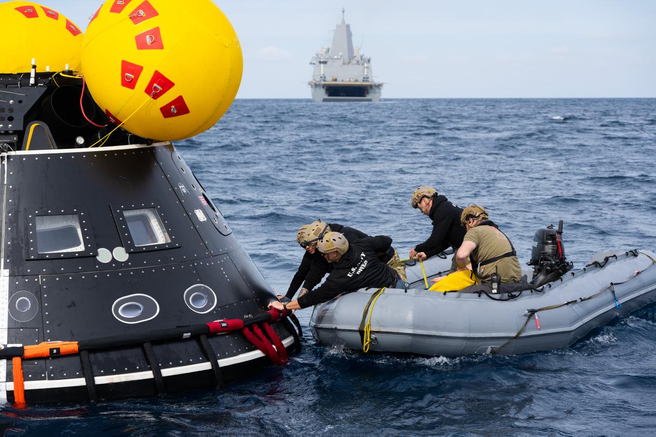 U.S. Navy personnel grab onto a mockup of the Orion spacecraft during a practice procedure of the Underway Recovery Test 11 (URT-11) off the coast of San Diego, California on Sunday, Feb. 25, 2024. URT-11 is the eleventh in a series of Artemis recovery tests, and the first time NASA and its partners put their Artemis II recovery procedures to the test with the astronauts. 