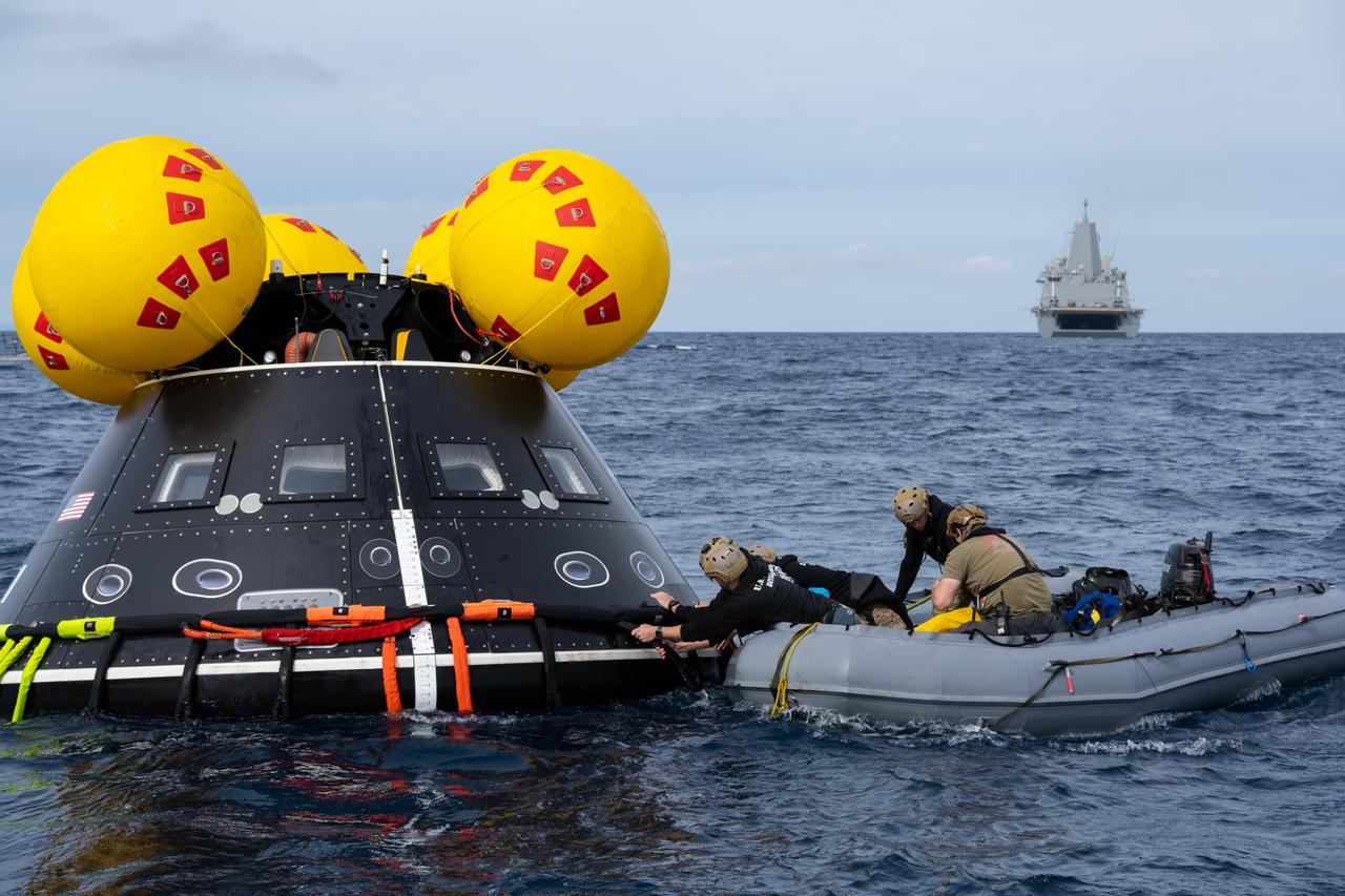 U.S. Navy personnel grab onto a mockup of the Orion spacecraft during a practice procedure of the Underway Recovery Test 11 (URT-11) off the coast of San Diego, California on Sunday, Feb. 25, 2024. URT-11 is the eleventh in a series of Artemis recovery tests, and the first time NASA and its partners put their Artemis II recovery procedures to the test with the astronauts