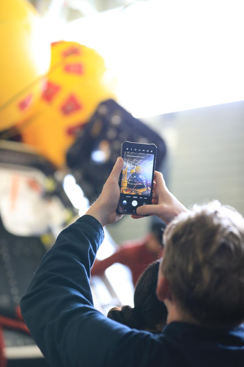 A member of NASA’s Exploration Ground System’s Landing and Recovery team takes a photo of a mockup of the Orion spacecraft during Underway Recovery Test 11 (URT-11) off the coast of San Diego, California on Monday, Feb. 26, 2024. URT-11 is the eleventh in a series of Artemis recovery tests, and the first time NASA and its partners put their Artemis II recovery procedures to the test with the astronauts. 