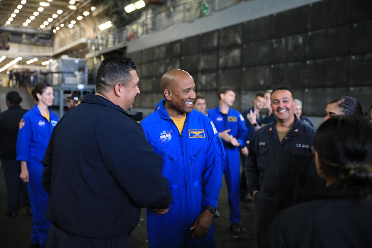 NASA’s Artemis II crew member Victor Glover and U.S. Navy personnel smile and talk following practice procedures aboard the USS San Diego during Underway Recovery Test 11 (URT-11) off the coast of San Diego, California on Monday, Feb. 26, 2024. URT-11 is the eleventh in a series of Artemis recovery tests, and the first time NASA and its partners put their Artemis II recovery procedures to the test with the astronauts. 