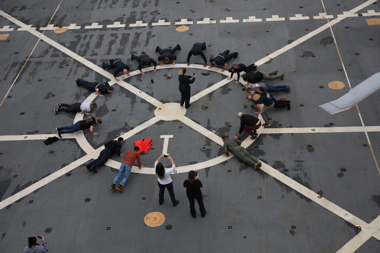 NASA’s Exploration Ground System’s Landing and Recovery team and partners from the Department of Defense aboard the USS San Diego do push-ups during Underway Recovery Test 11 (URT-11) off the coast of San Diego on Monday, Feb. 26, 2024. URT-11 is the eleventh in a series of Artemis recovery tests, and the first time NASA and its partners put their Artemis II recovery procedures to the test with the astronauts.