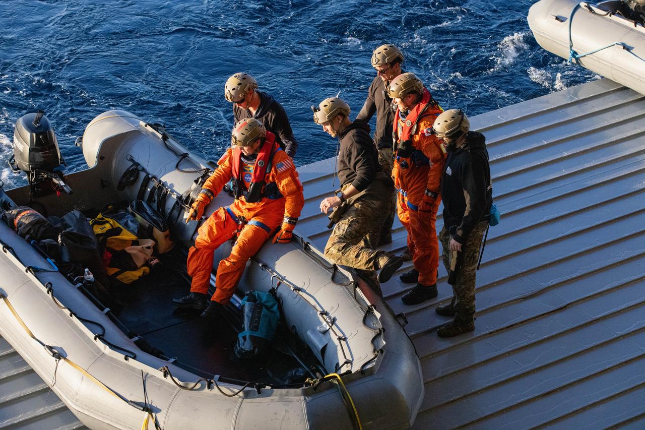 NASA’s Exploration Ground System’s Landing and Recovery team, partners from the Department of Defense, and U.S. Navy personnel aboard the USS San Diego assist NASA’s Artemis II crew members from left to right NASA astronaut Reid Wiseman and CSA (Canadian Space Agency) astronaut Jeremy Hansen prepare to push off the well deck in a boat to head to the mockup of the Orion spacecraft during practice recovery procedures during Underway Recovery Test 11 (URT-11) off the coast of San Diego, California on Tuesday, Feb. 27, 2024. URT-11 is the eleventh in a series of Artemis recovery tests, and the first time NASA and its partners put their Artemis II recovery procedures to the test with the astronauts.