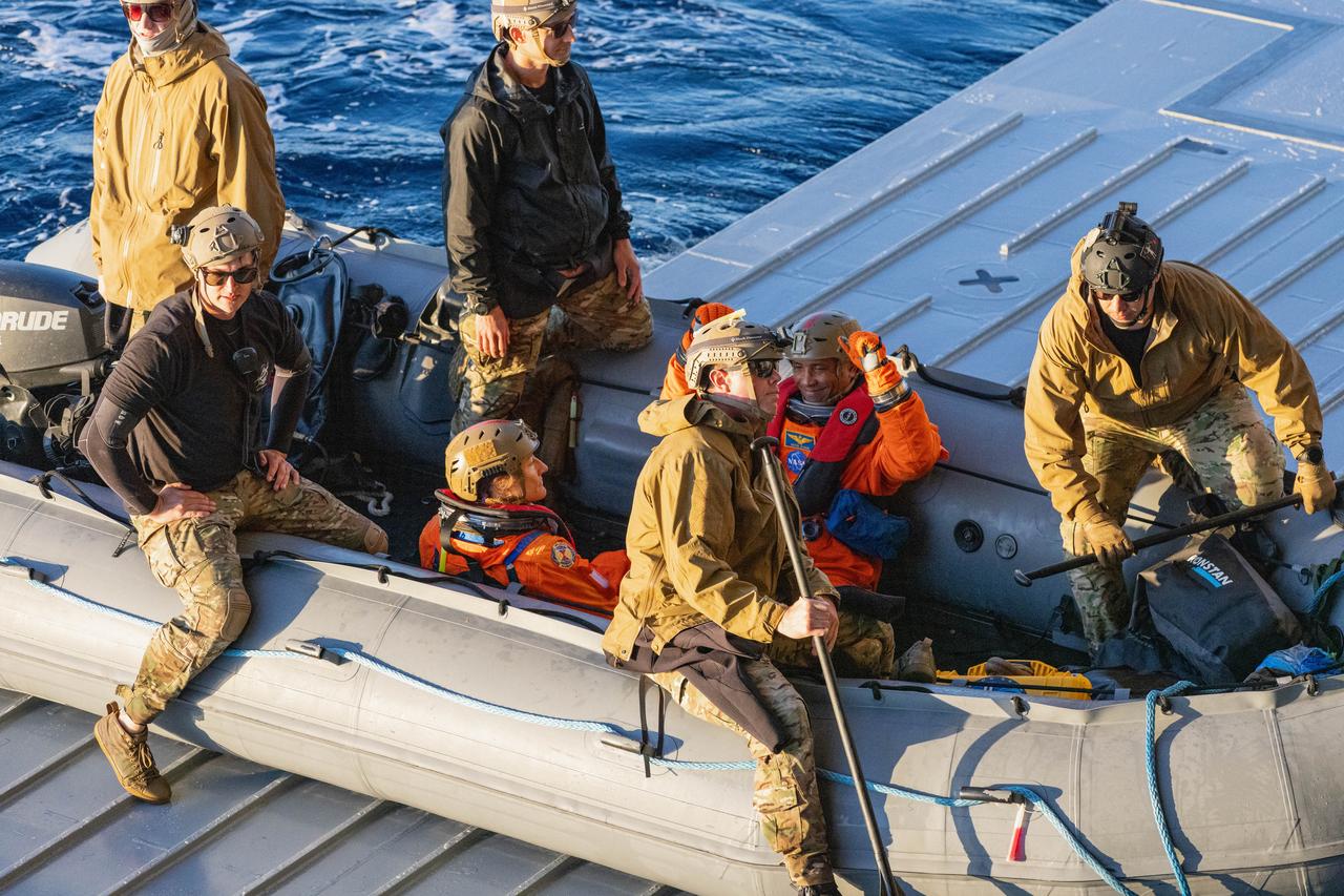 NASA’s Exploration Ground System’s Landing and Recovery team, partners from the Department of Defense, and U.S. Navy personnel aboard the USS San Diego assist NASA’s Artemis II crew members from left to right NASA astronauts Christina Koch and Victor Glover from a boat during practice recovery procedures during Underway Recovery Test 11 (URT-11) off the coast of San Diego, California on Tuesday, Feb. 27, 2024. URT-11 is the eleventh in a series of Artemis recovery tests, and the first time NASA and its partners put their Artemis II recovery procedures to the test with the astronauts.