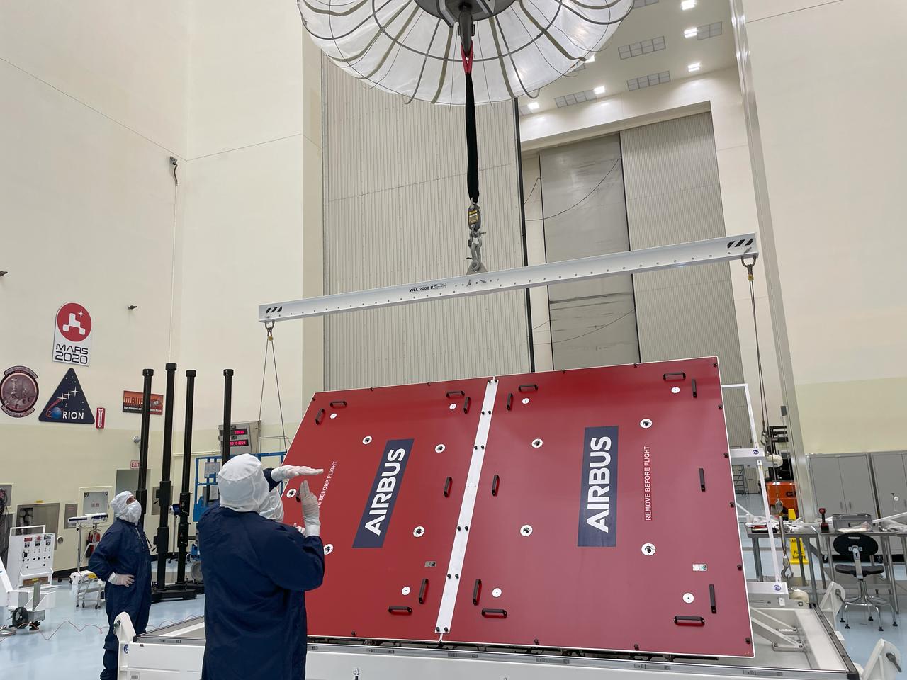 Technicians hoist a five-panel solar array protected by a lid for NASA’s Europa Clipper spacecraft at the Payload Hazardous Servicing Facility at the agency’s Kennedy Space Center in Florida on Tuesday, Feb. 27, 2024. The arrays are each 46.5 feet long (14.2 meters). With both solar arrays deployed, Europa Clipper will span more than 100 feet long, about the length of a basketball court. The solar arrays power the spacecraft so it can study Jupiter’s icy moon, Europa, which is more than five times as far from the Sun as the Earth. Launch on a SpaceX Falcon Heavy rocket is no earlier than October 2024.