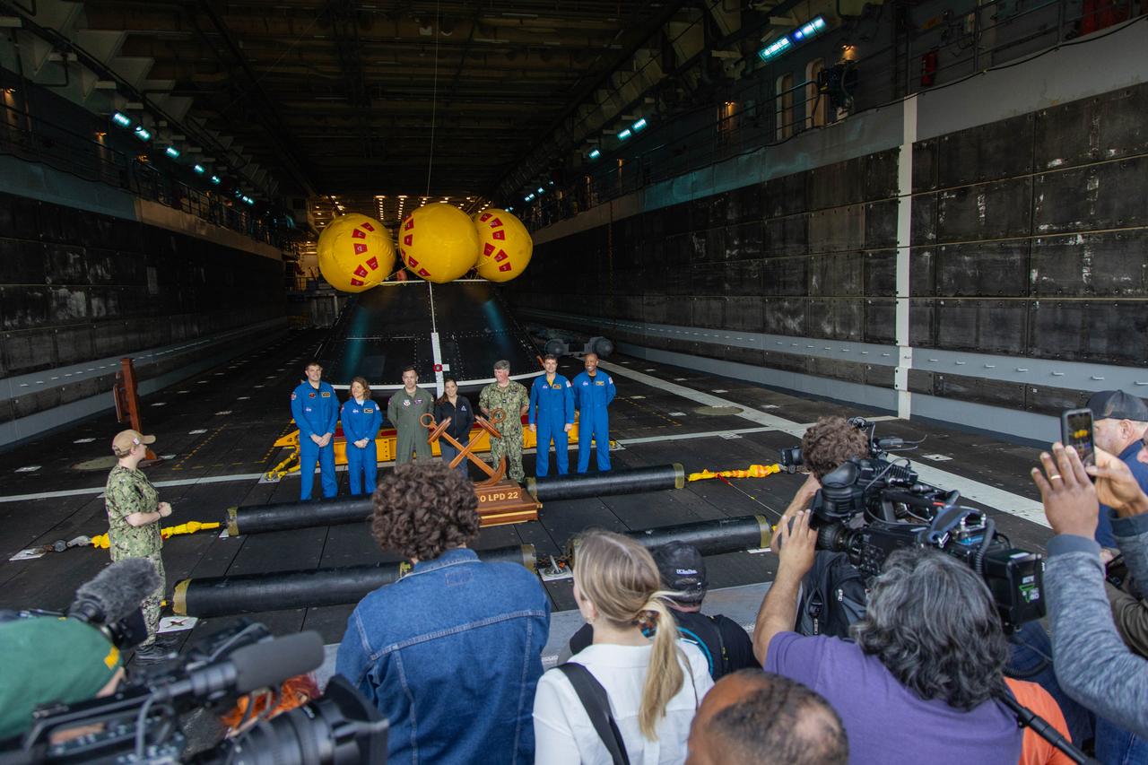 NASA’s Artemis II crew members from right to left, CSA (Canadian Space Agency) astronaut Jeremy Hansen, NASA astronaut Christina Koch, NASA’s Exploration Ground System’s Landing and Recovery team, partners from the Department of Defense, and NASA astronauts Reid Wiseman, and Victor Glover, pose for a photo near a  mockup Orion spacecraft in San Diego, California on Wednesday, Feb. 28, 2024, as part of the Underway Recovery Test (URT-11). URT-11, aboard the USS San Diego, is the eleventh in a series of Artemis recovery tests, and the first time NASA and its partners put their Artemis II recovery procedures to the test with the astronauts.