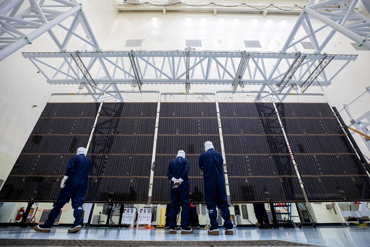 Technicians examine the first of two fully extended five-panel solar arrays built for NASA’s Europa Clipper suspended on a support system called a gravity offload fixture during inspection and cleaning as part of assembly, test, and launch operations inside the Payload Hazardous Servicing Facility at the agency’s Kennedy Space Center in Florida on Wednesday, March 6, 2024. Another name for the gravity offload fixture is the Transportable Large Envelope Deployment Facility (T-LEDF). When both solar arrays are installed and deployed on Europa Clipper – the agency’s largest spacecraft ever developed for a planetary mission – the spacecraft will span a total length of more than 100 feet and weigh 7,145 pounds without the inclusion of propellants.     