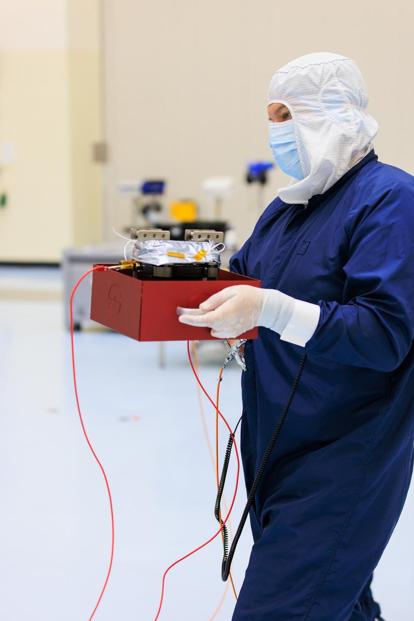 On Wednesday, March 20, 2024, a technician inside the Payload Hazardous Servicing Facility at NASA’s Kennedy Space Center in Florida carries an antenna that will attach to a solar array for the agency’s Europa Clipper spacecraft, which will study Jupiter’s icy moon Europa to determine if the planet has conditions that could support life. The REASON, (Radar for Europa Assessment and Sounding: Ocean to Near-surface) instrument will use the antennas to send both High Frequency (HF) and Very High Frequency (VHF) radio waves to penetrate up to 18 miles (30 kilometers) deep and search the ocean, measure ice thickness, and study the topography, composition, and roughness of Europa’s surface. The Europa Clipper spacecraft will ship to Florida later this year from NASA’s Jet Propulsion Lab in Southern California in preparation for launch aboard a SpaceX Falcon Heavy rocket from Kennedy’s Launch Complex 39A targeting October 2024.