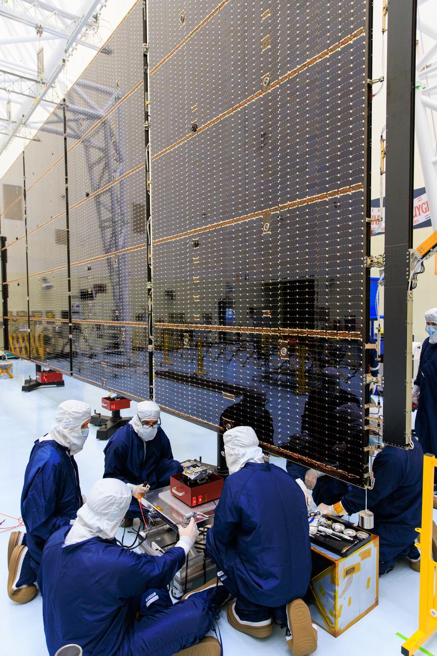 Technicians inside the Payload Hazardous Servicing Facility at NASA’s Kennedy Space Center in Florida install and test one of several antennas on a solar array Wednesday, March 20, 2024, for the agency’s Europa Clipper spacecraft which will study Jupiter’s icy moon Europa to determine if the planet has conditions that could support life. REASON, (Radar for Europa Assessment and Sounding: Ocean to Near-surface) instrument will use the antennas to send both High Frequency (HF) and Very High Frequency (VHF) radio waves to penetrate up to 18 miles (30 kilometers) deep and search the ocean, measure ice thickness, and study the topography, composition, and roughness of Europa’s surface. The Europa Clipper spacecraft will ship to Florida later this year from NASA’s Jet Propulsion Lab in Southern California in preparation for launch aboard a SpaceX Falcon Heavy rocket from Kennedy’s Launch Complex 39A targeting October 2024.