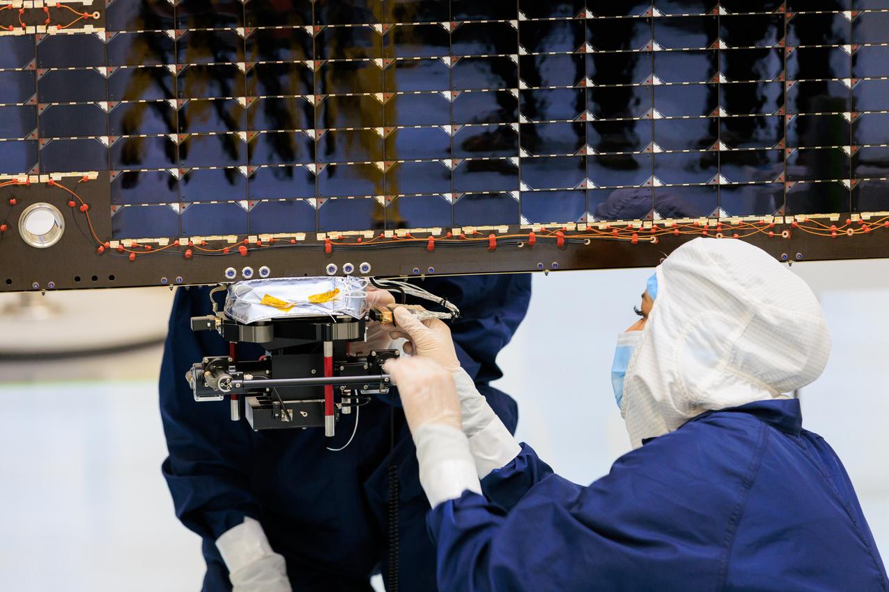 Technicians inside the Payload Hazardous Servicing Facility at NASA’s Kennedy Space Center in Florida install and test antennas on a solar array on Wednesday, March 20, 2024, for the agency’s Europa Clipper spacecraft which will study Jupiter’s icy moon Europa to determine if the planet has conditions that could support life. The REASON, (Radar for Europa Assessment and Sounding: Ocean to Near-surface) instrument will use the antennas to send both both High Frequency (HF) and Very High Frequency (VHF)  radio waves to penetrate up to 18 miles (30 kilometers) deep and search the ocean, measure ice thickness, and study the topography, composition, and roughness of Europa’s surface. The Europa Clipper spacecraft will ship to Florida later this year from NASA’s Jet Propulsion Lab in Southern California in preparation for launch aboard a SpaceX Falcon Heavy rocket from Kennedy’s Launch Complex 39A targeting October.