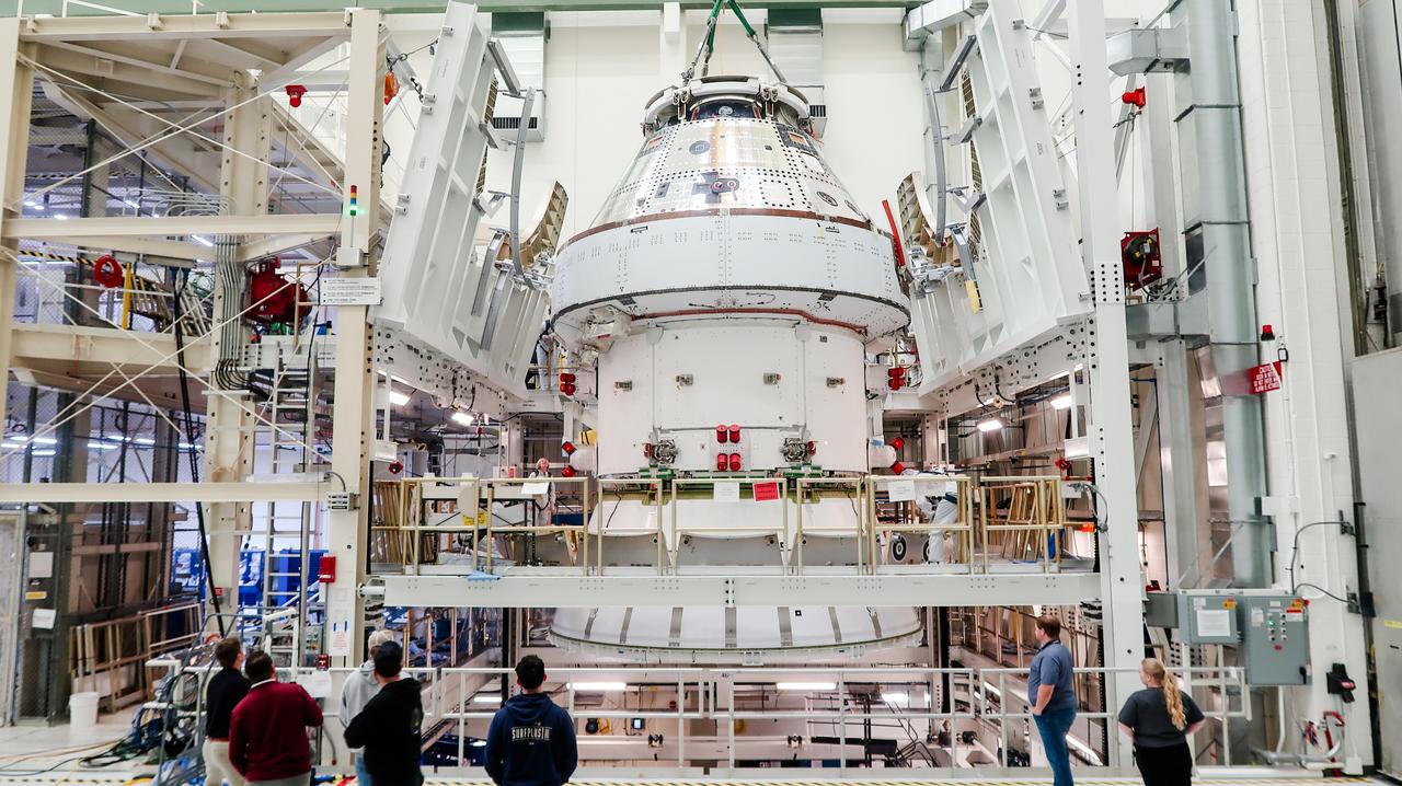 On April 4, 2024, a team lifts the Artemis II Orion spacecraft into a vacuum chamber inside the Operations and Checkout Building at NASA's Kennedy Space Center in Florida, where it will undergo electromagnetic compatibility and interference testing.