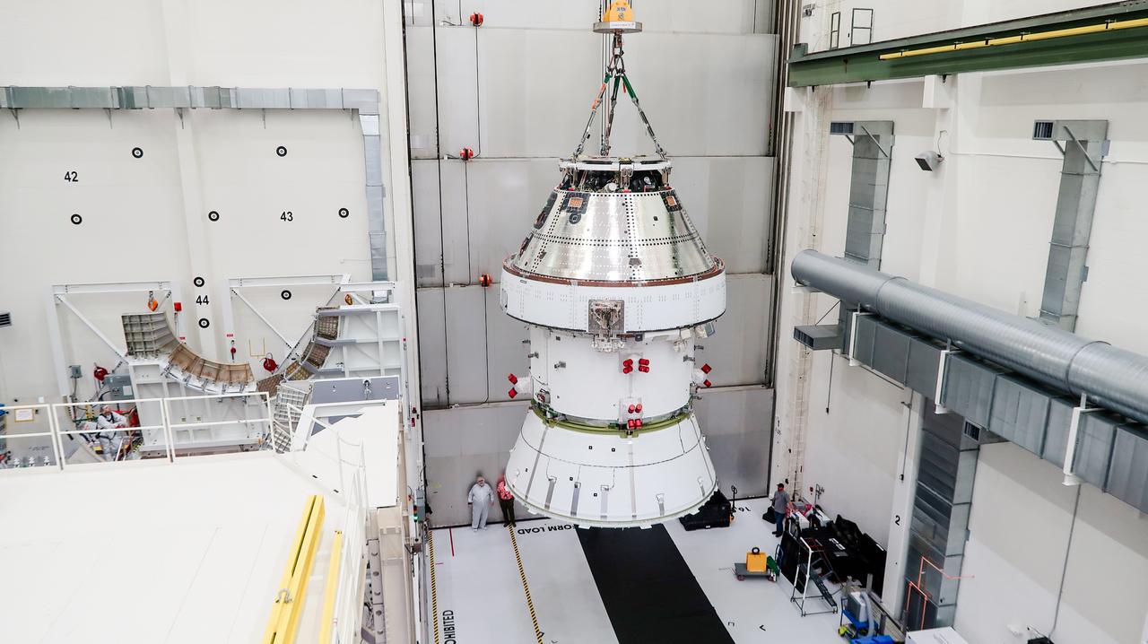 On April 4, 2024, a team lifts the Artemis II Orion spacecraft into a vacuum chamber inside the Operations and Checkout Building at NASA's Kennedy Space Center in Florida, where it will undergo electromagnetic compatibility and interference testing.