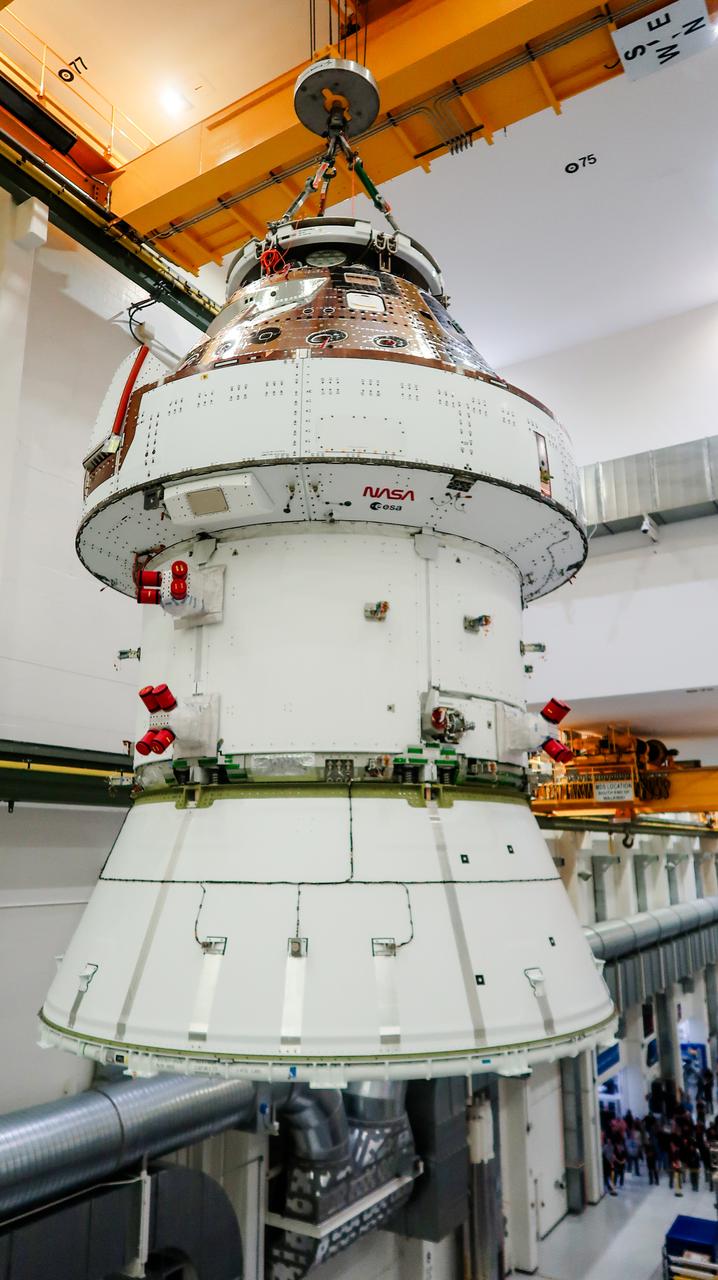 On April 4, 2024, a team lifts the Artemis II Orion spacecraft into a vacuum chamber inside the Operations and Checkout Building at NASA's Kennedy Space Center in Florida, where it will undergo electromagnetic compatibility and interference testing.