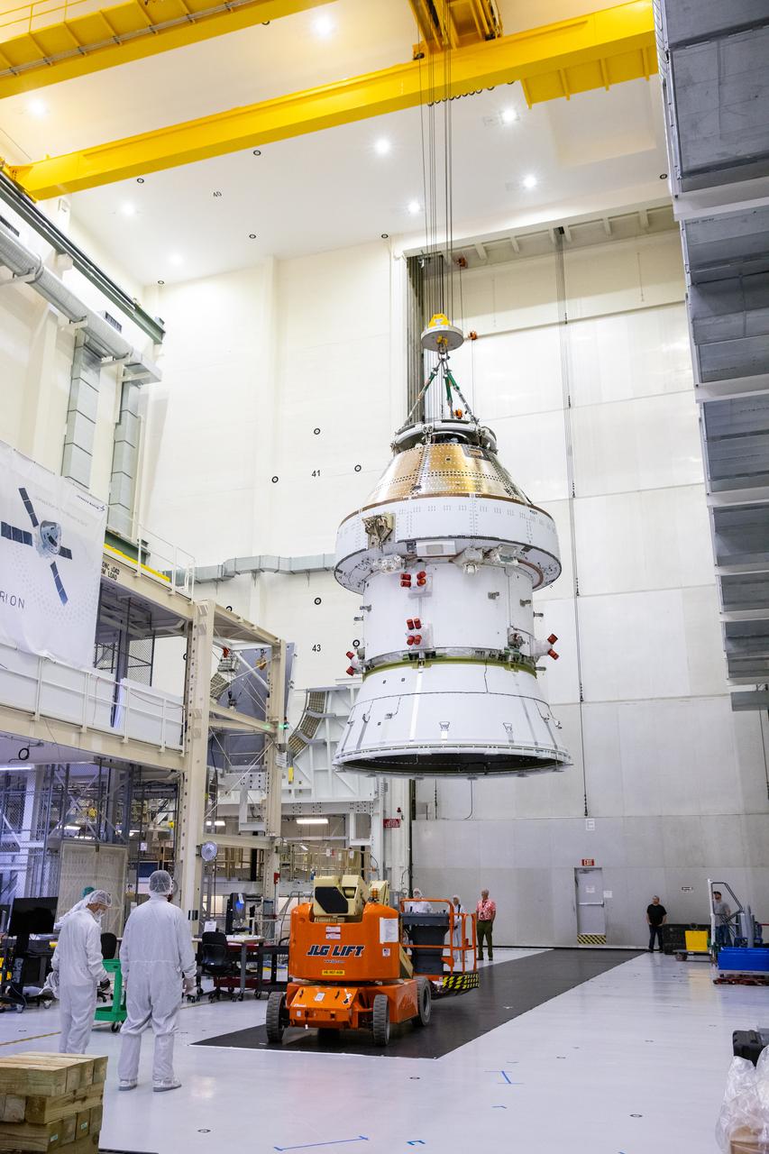 On April 4, 2024, technicians monitor as teams lift the Artemis II Orion spacecraft into a vacuum chamber inside the Operations and Checkout Building at NASA's Kennedy Space Center in Florida, where it will undergo electromagnetic compatibility and interference testing. 
