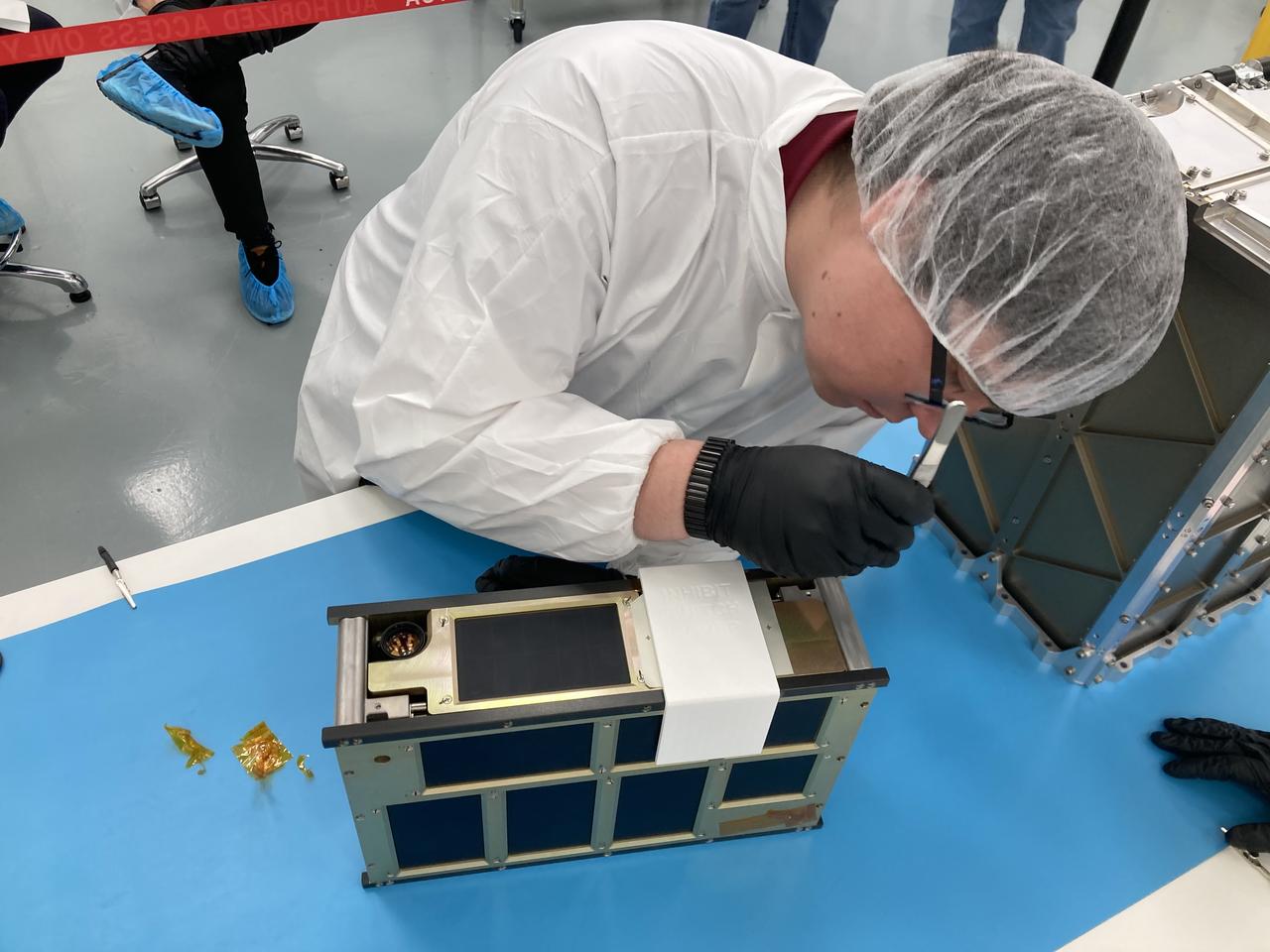 NASA engineer Jacob Nunez-Kearny removes foreign object debris (FOD) cover from the propulsion system on the agency’s CubeSat R5 Spacecraft 4 (R5-S4) at Firefly Aerospace’s Payload Processing Facility at Vandenberg Space Force Base, California on Wednesday, April 24, 2024. The spacecraft will soon be integrated for launch aboard the company’s Alpha rocket, as part of launch services provided for NASA's CubeSat Launch Initiative and Educational Launch of Nanosatellites 43 mission in support of the agency ’s Venture-Class Launch Services Demonstration 2 contract.