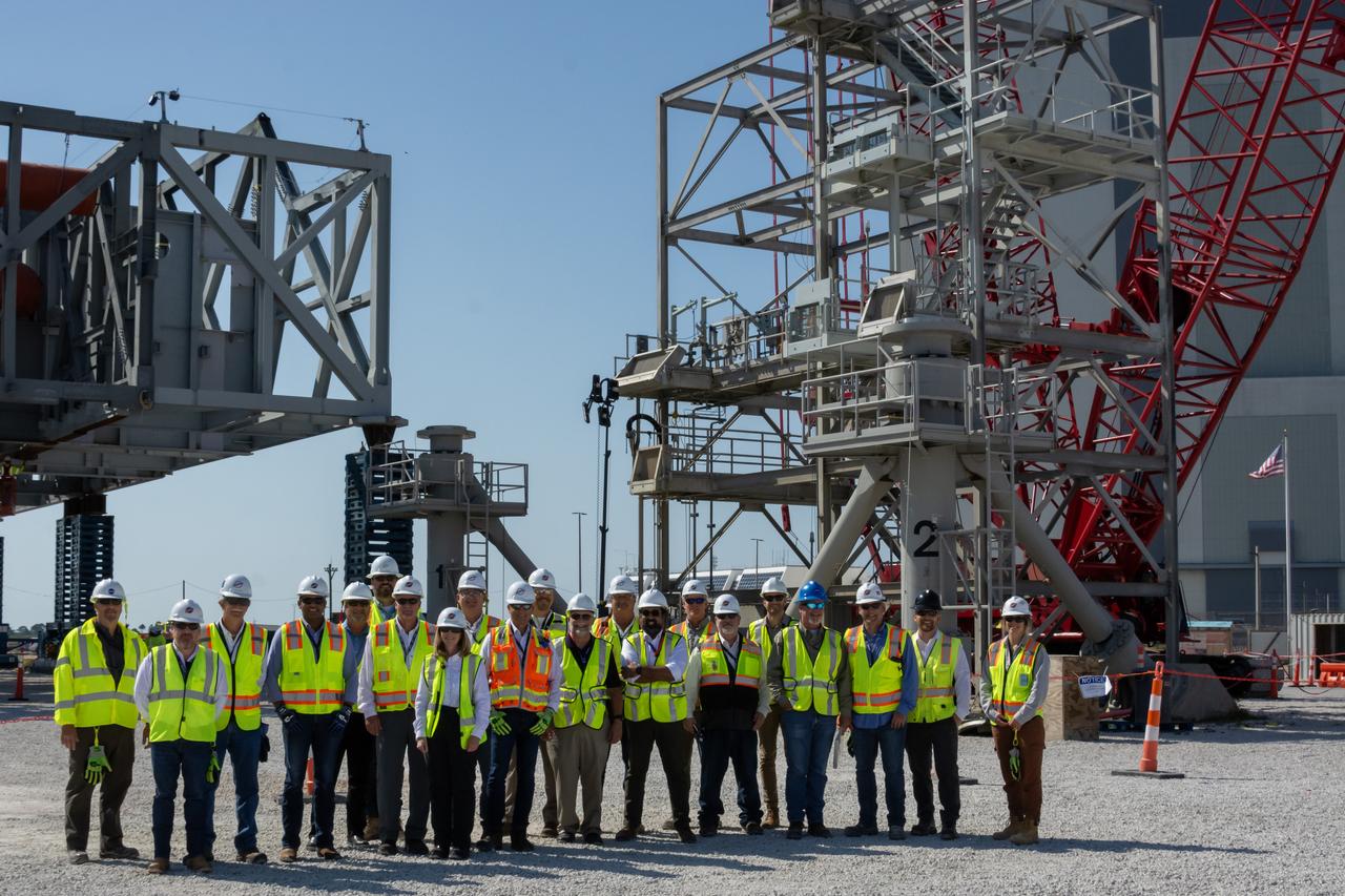 Teams with NASA’s Exploration Ground Systems Program and primary contractor, Bechtel National, Inc., pose for a photo near construction of a permanent mount structure where they will continue building the agency’s new mobile launcher 2 at Kennedy Space Center in Florida on Thursday, May 9, 2024. The 355-foot-tall mobile launcher 2 with a two-story base and a tower will be used to assemble and process the SLS (Space Launch System) rocket and Orion spacecraft in the Vehicle Assembly Building on NASA’s upcoming Artemis missions to the Moon beginning with Artemis IV.